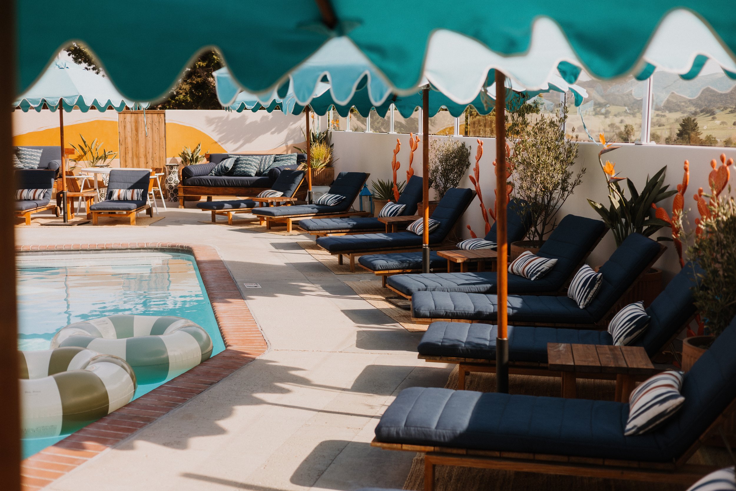Lounge chairs by heated pool with food and drinks at Skyview Los Alamos