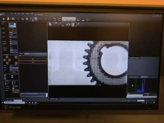 Computer monitored screen displaying a black and white image of a gear or cogwheel in photo editing or viewing software.
