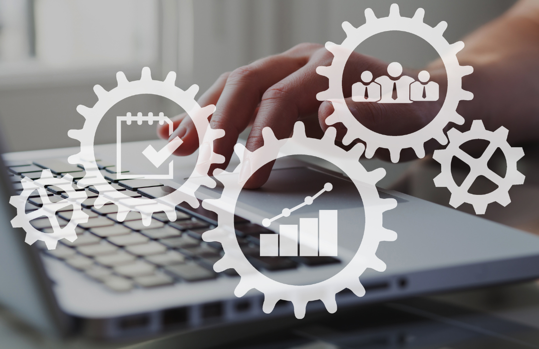 A person typing on a laptop keyboard with overlay icons representing gears, charts, a calendar, and people, symbolizing productivity, teamwork, and project management.