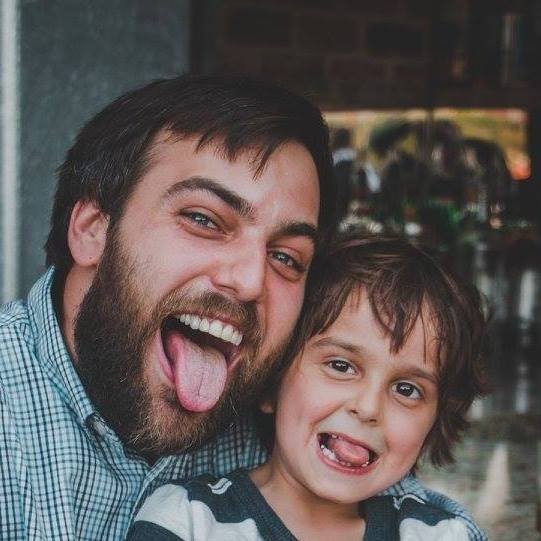 A man and a young boy making funny faces together.