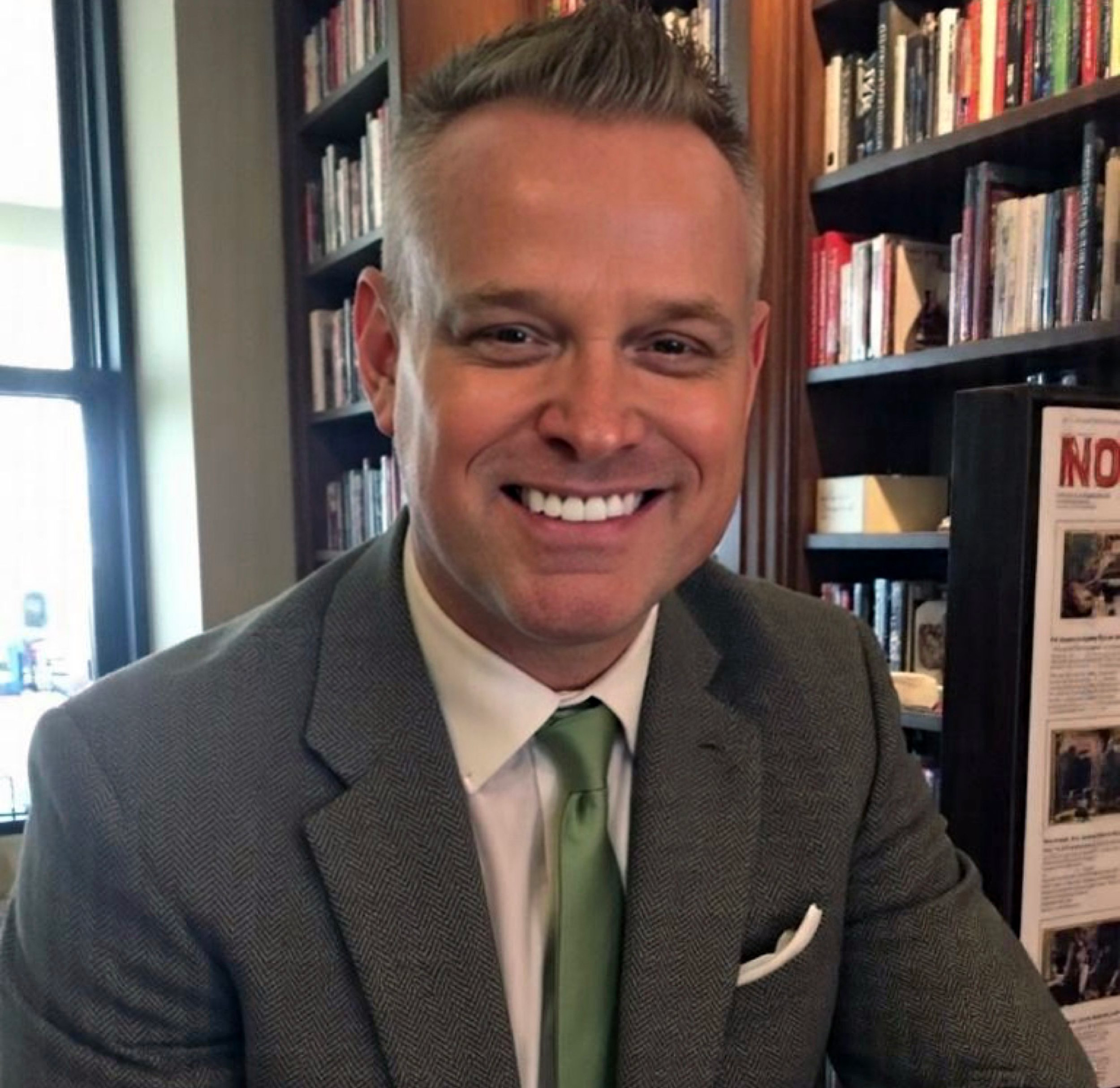 RJ Starr, psychology educator and independent scholar, seated in a study with bookshelves
