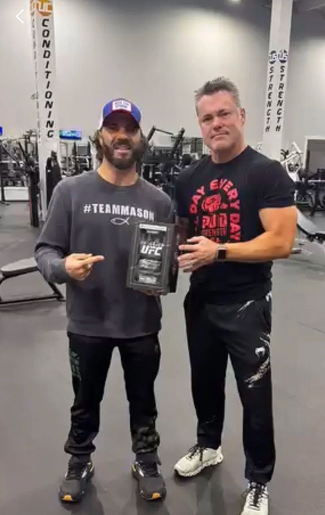 Boxer with red headgear and rooster tattoo preparing for a match in a boxing ring.