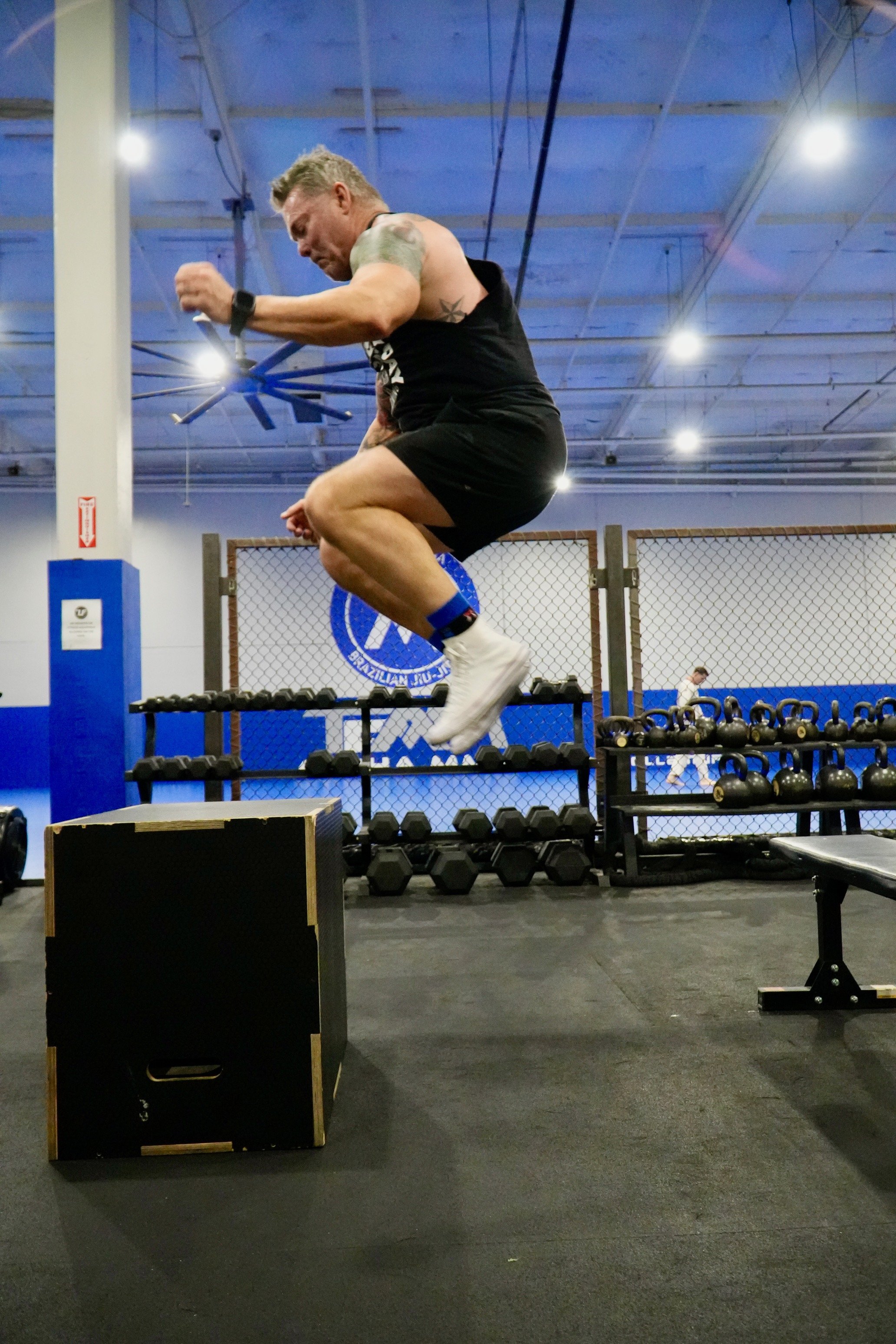 Rowing machine in gym with people walking nearby