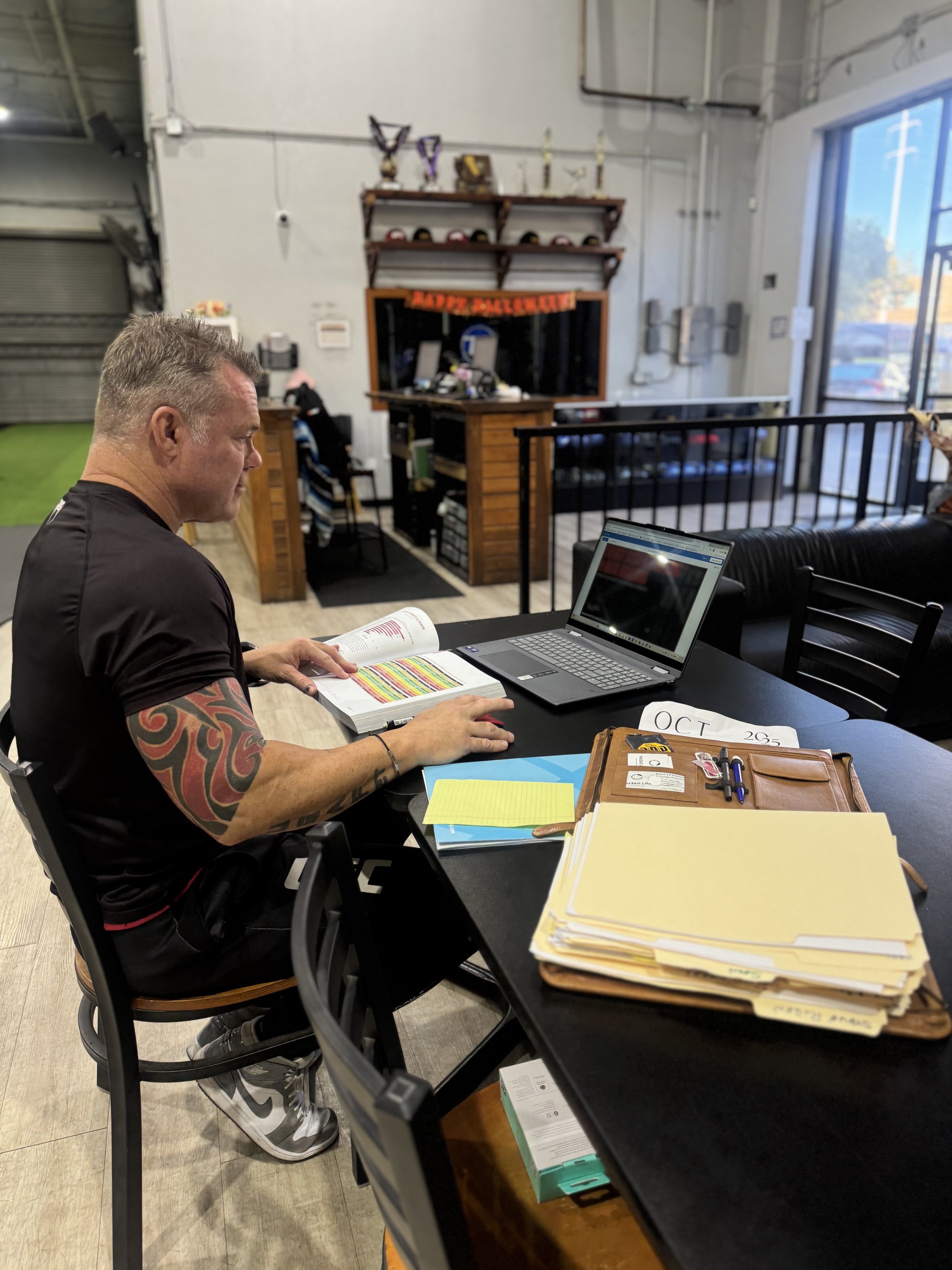 Person doing yoga on a mat at home, practicing downward dog pose, surrounded by plants.
