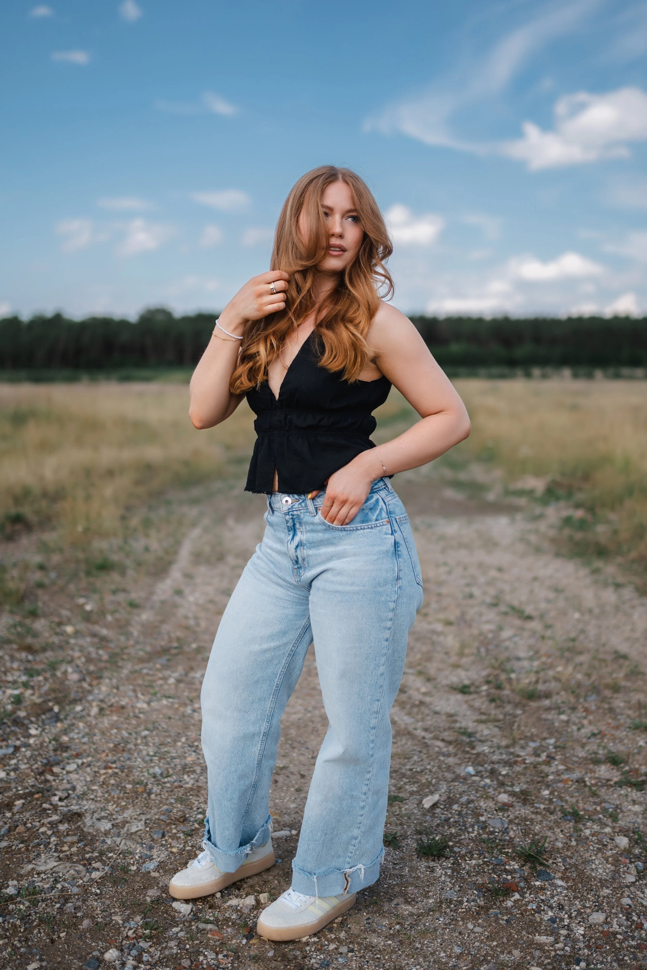  Outdoor Portrait Oberpfalz, Maggi in heller Wide-Leg-Jeans auf einem Feldweg am Steinberger See, blauer Sommerhimmel 