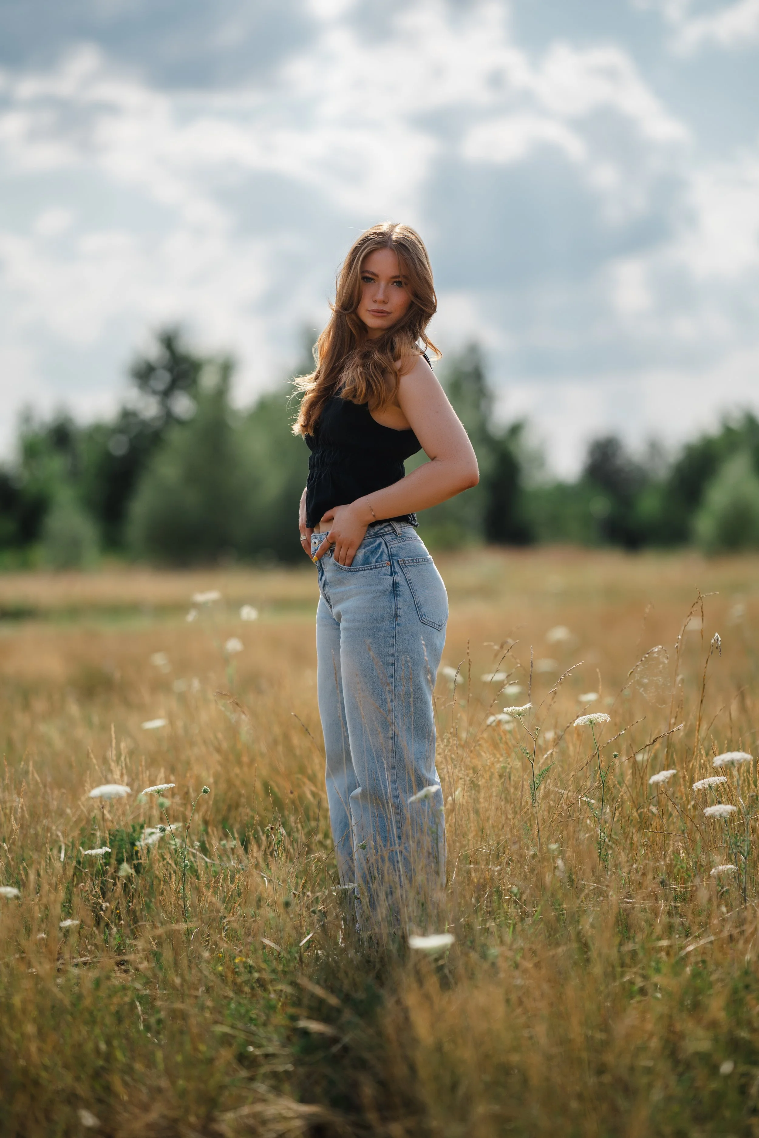  Outdoor Portrait Oberpfalz, Maggi in heller Wide-Leg-Jeans auf einem Feldweg am Steinberger See, blauer Sommerhimmel 