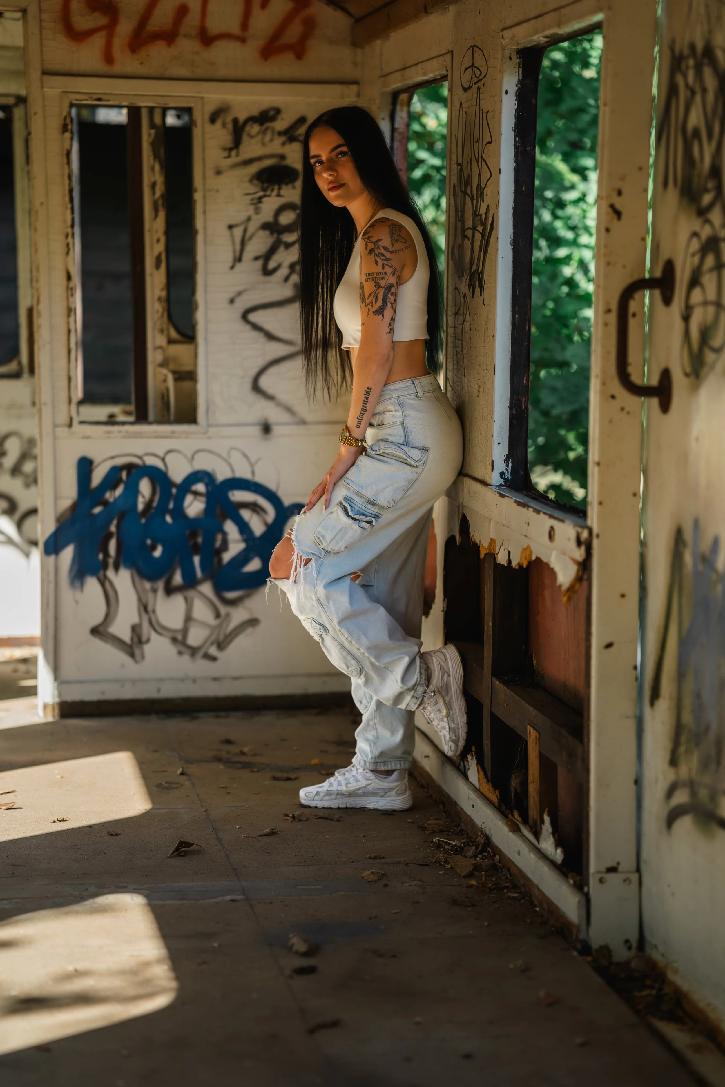 tuerrahmen.jpg	Jennifer lacht im Türrahmen eines verlassenen Eisenbahnwaggons und hält eine Hand locker am Rahmen. ganzkoerperportrait-jennifer-waggon-fenster.jpg