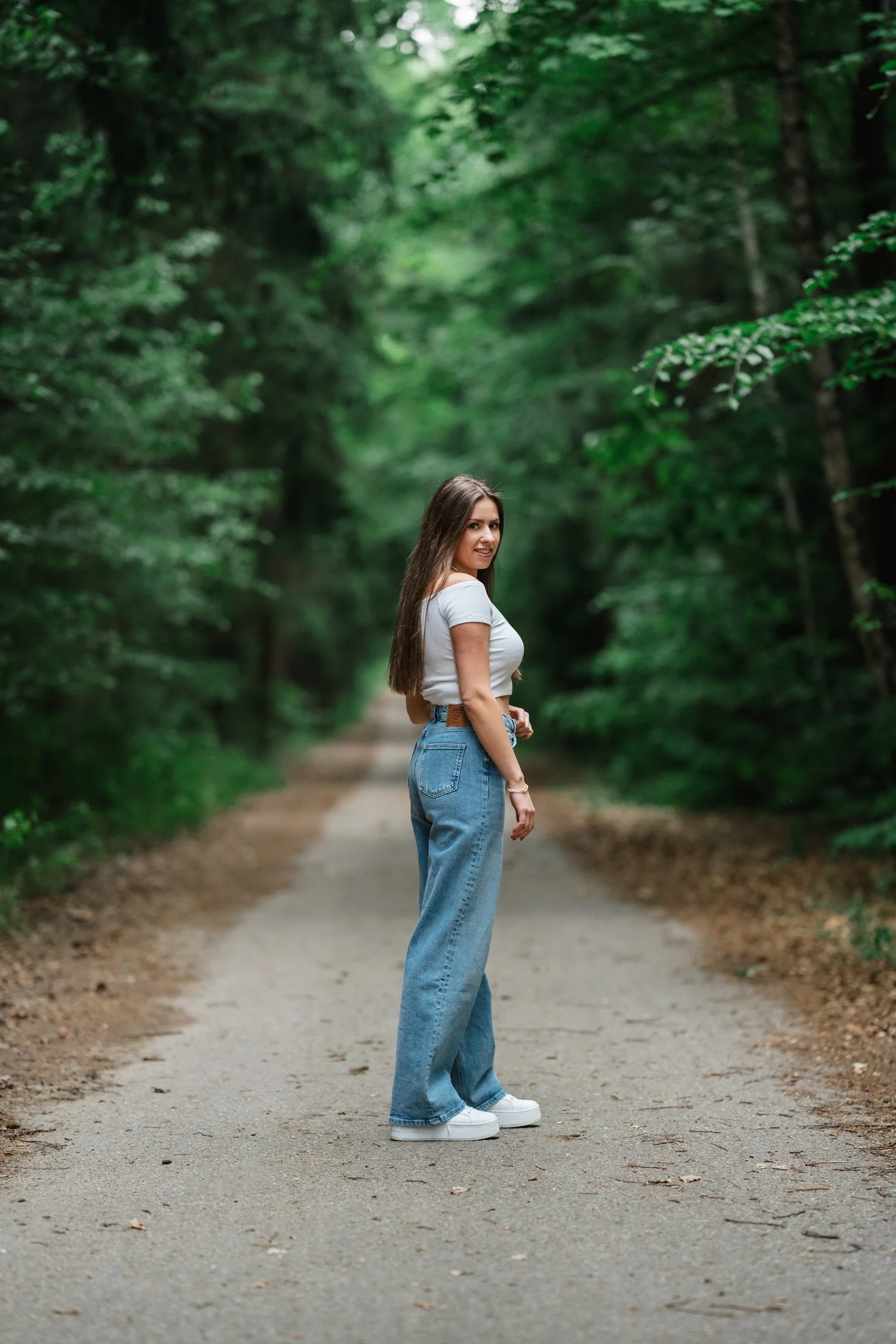Portrait auf einem schattigen Waldweg mit sichtbarer räumlicher Tiefe