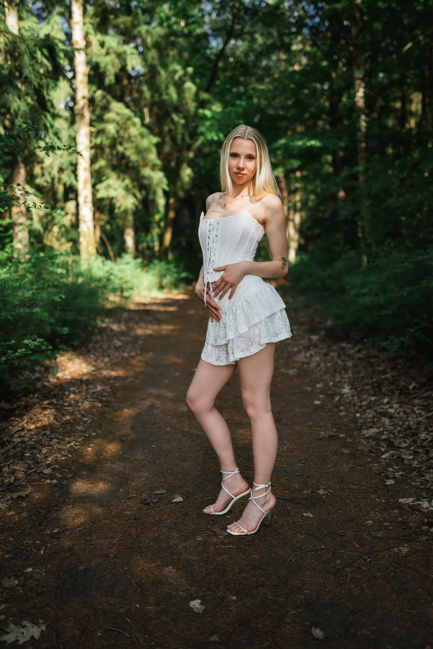 Ganzkörperportrait auf einem sonnenbeschienenen Waldweg