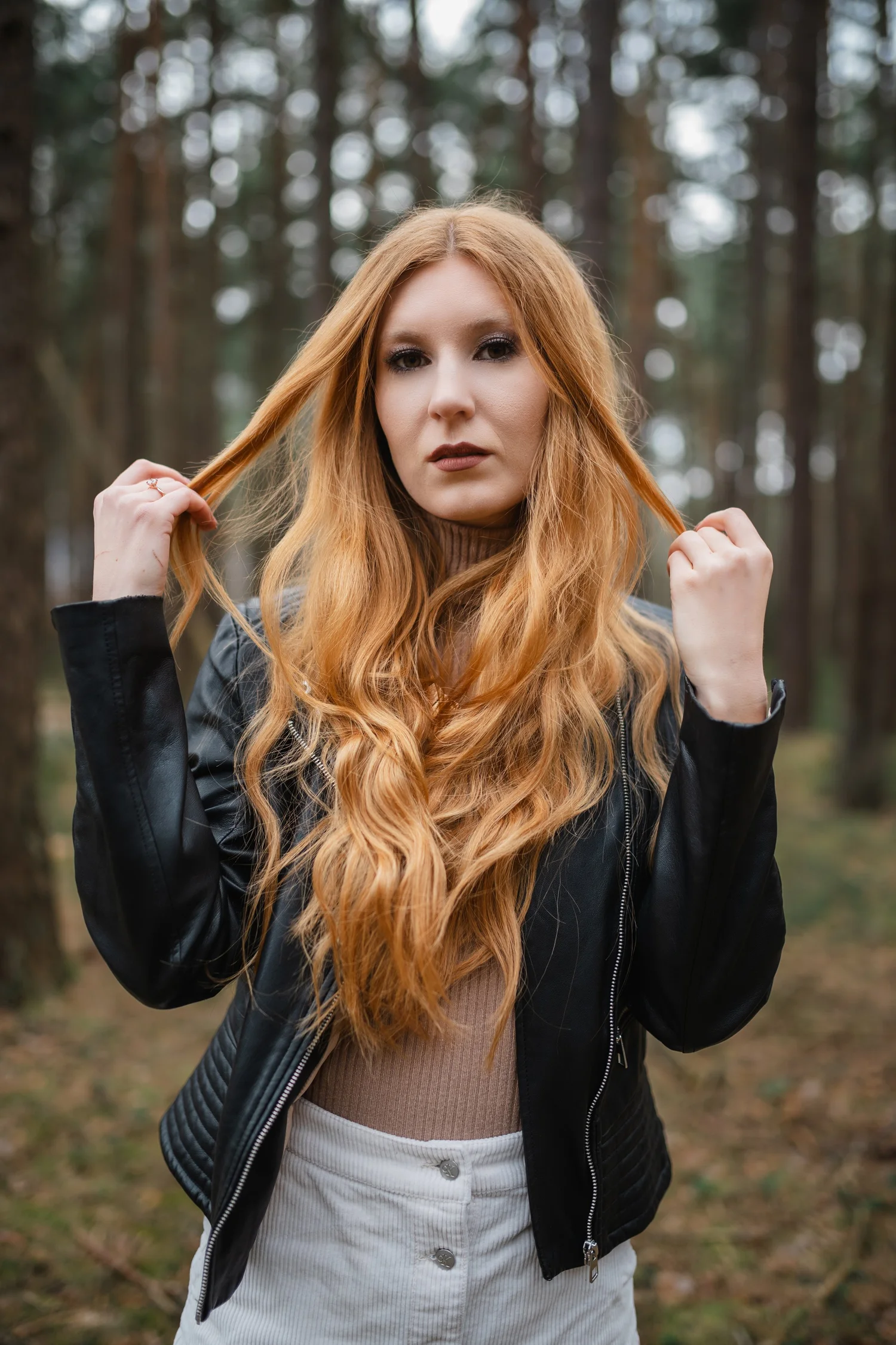 Portrait im Wald mit einer Pose, bei der die Hände die Haare berühren
