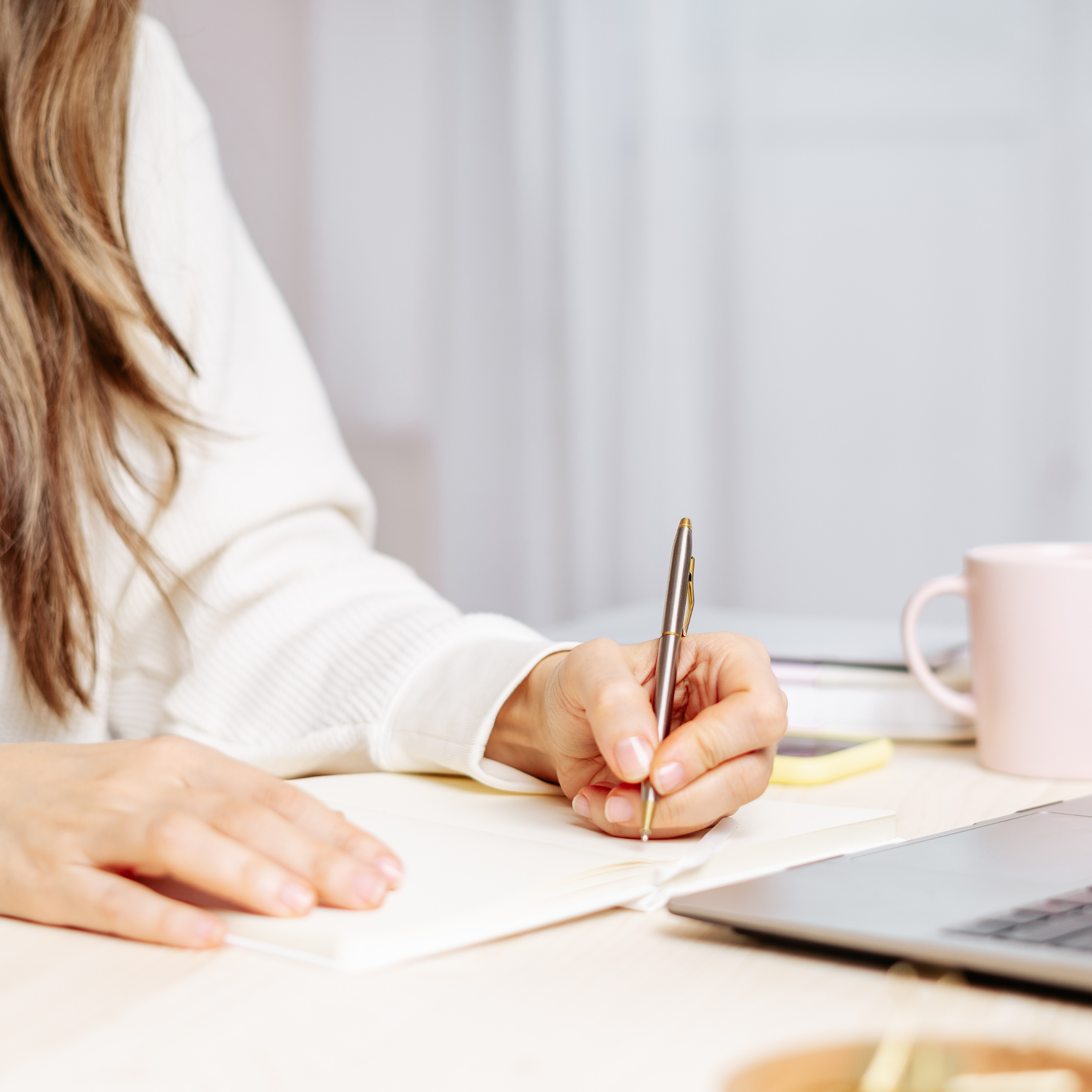 Writing a great marketing plan with a gold pen and notebook