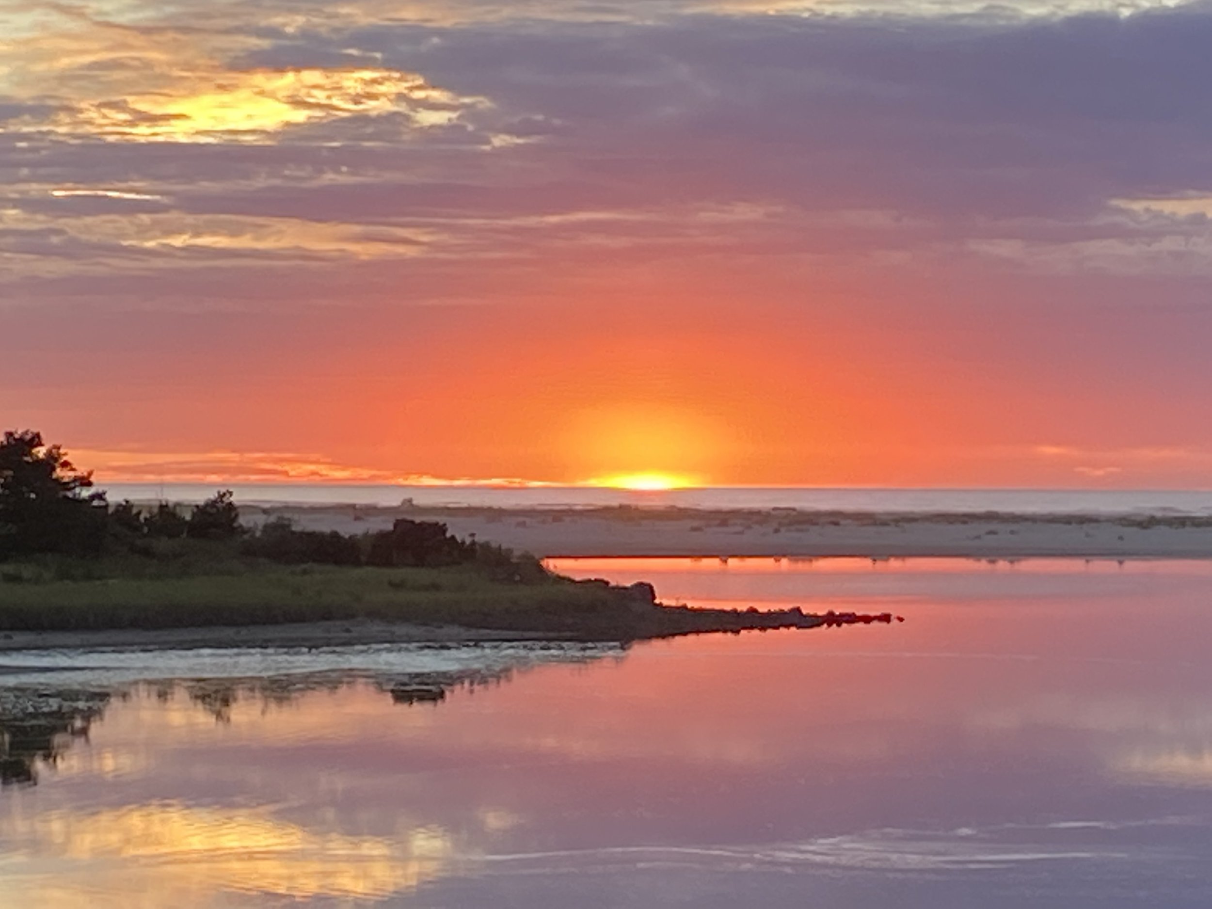 Sunset over a body of water with colorful sky and reflection on the water