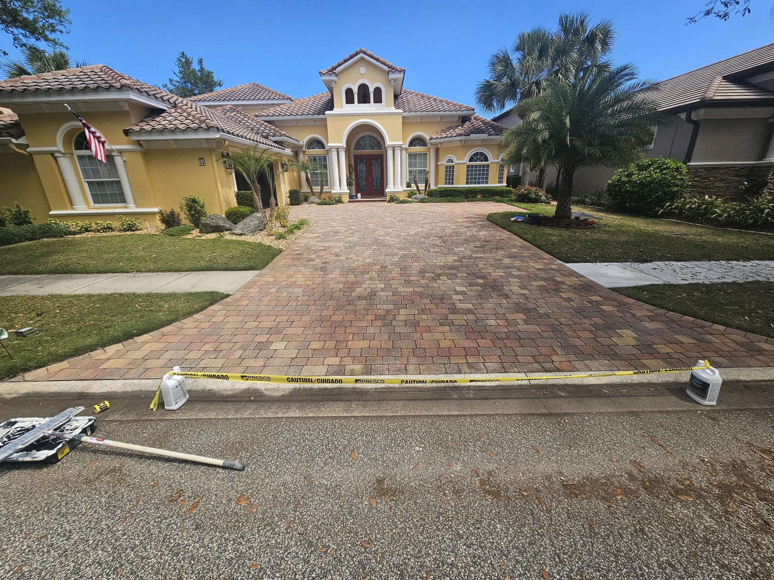 Palm Coast home after pressure washing pavers driveway and applying latex based sealant.