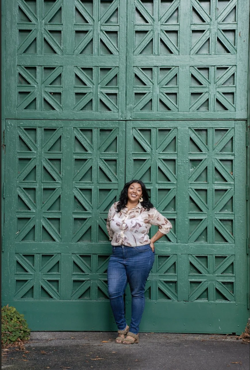Woman  standing in front of green wall smiling