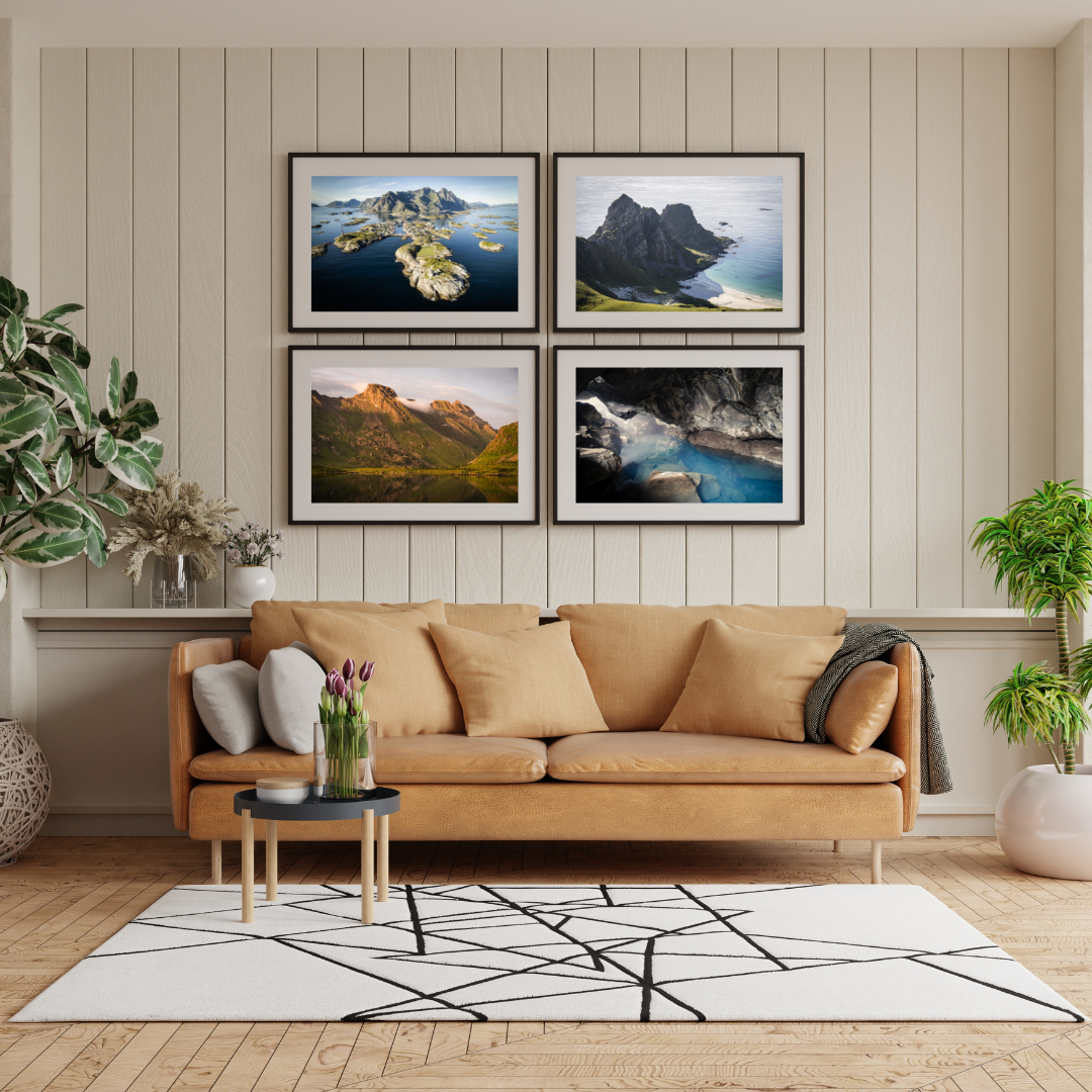 Living room with beige sofa, black and white geometric rug, wall art of landscape photos, potted plants, vase with flowers, and small coffee table.