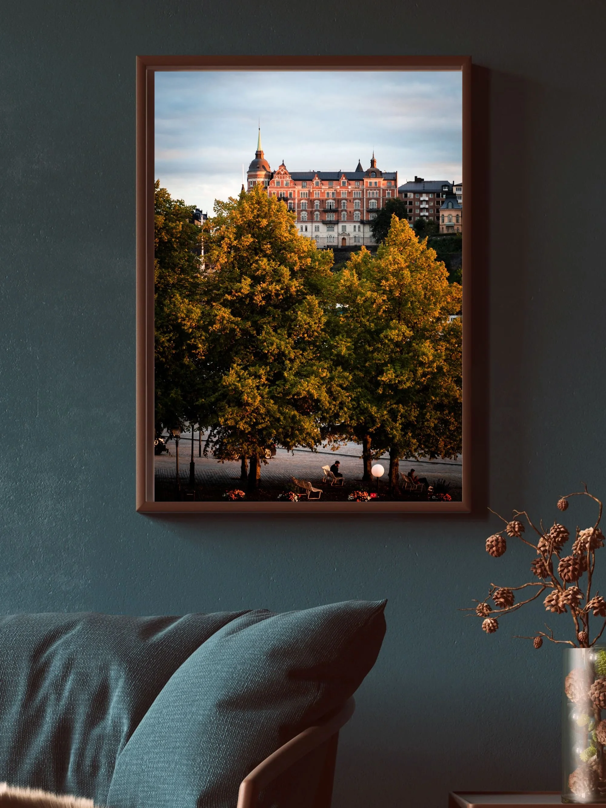 Framed cityscape view through window with trees, park benches, and buildings in the background.