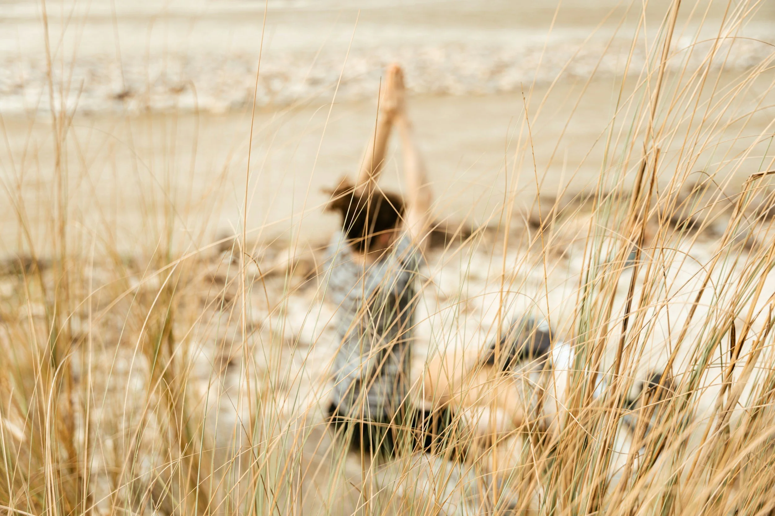 Frau sitzt meditierend am Strand