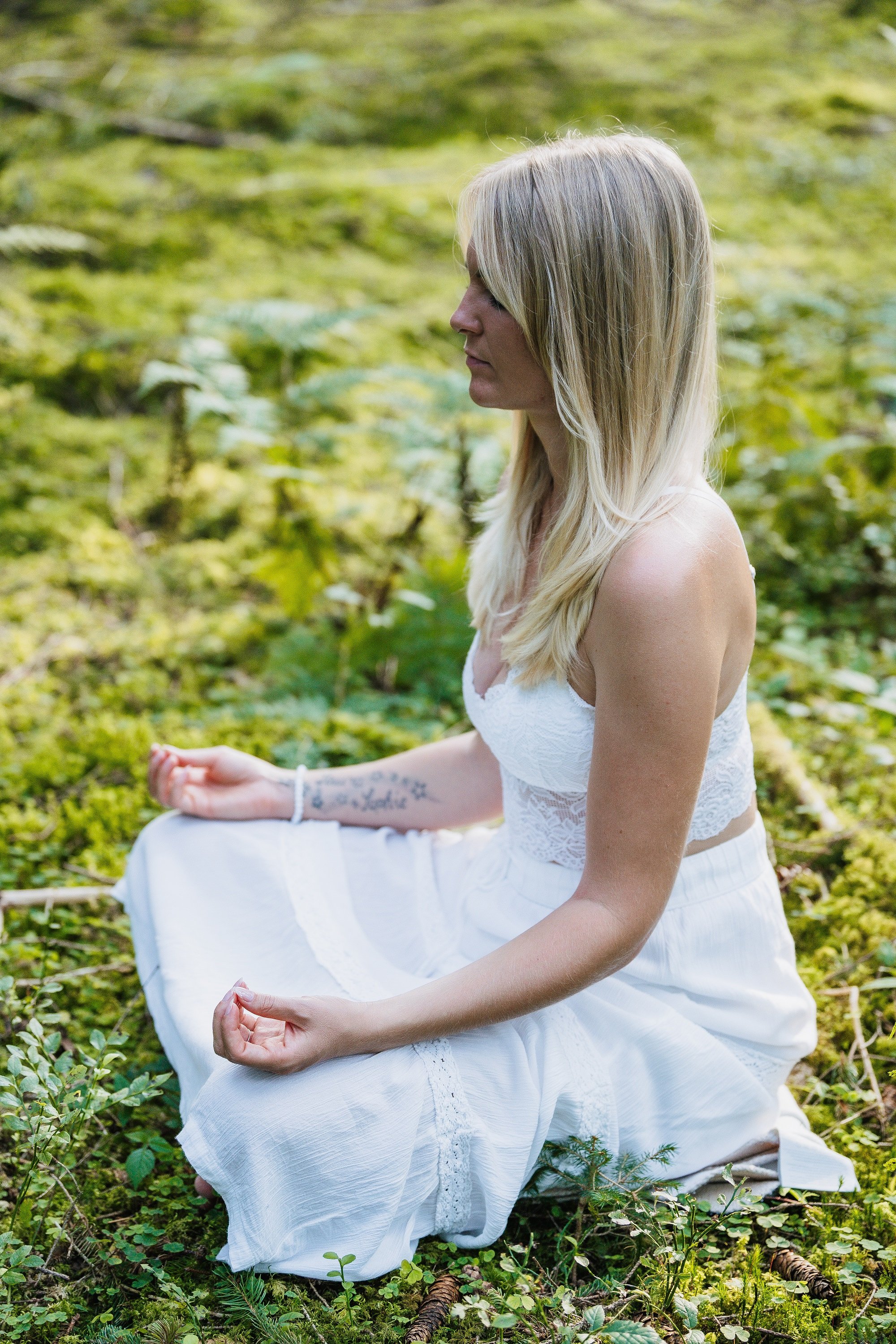 Kathrin Pörner sitzt meditierend im Wald