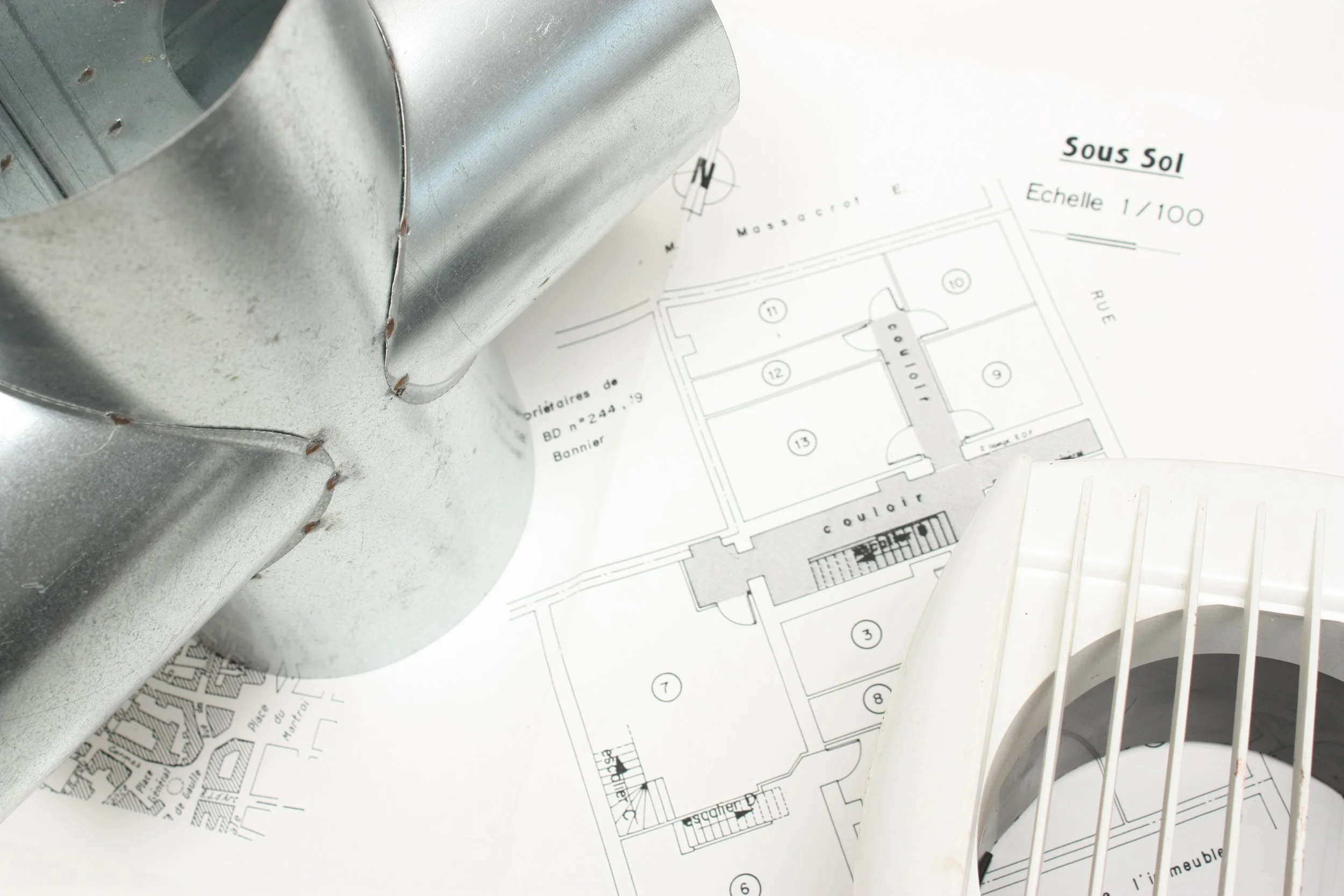 Un technicien de maintenance ou électricien avec une ceinture d'outils contenant des pinceaux, un tournevis, une pince, et d'autres outils, portant un casque de sécurité jaune et des gants en cuir, tenant plusieurs câbles électriques.
