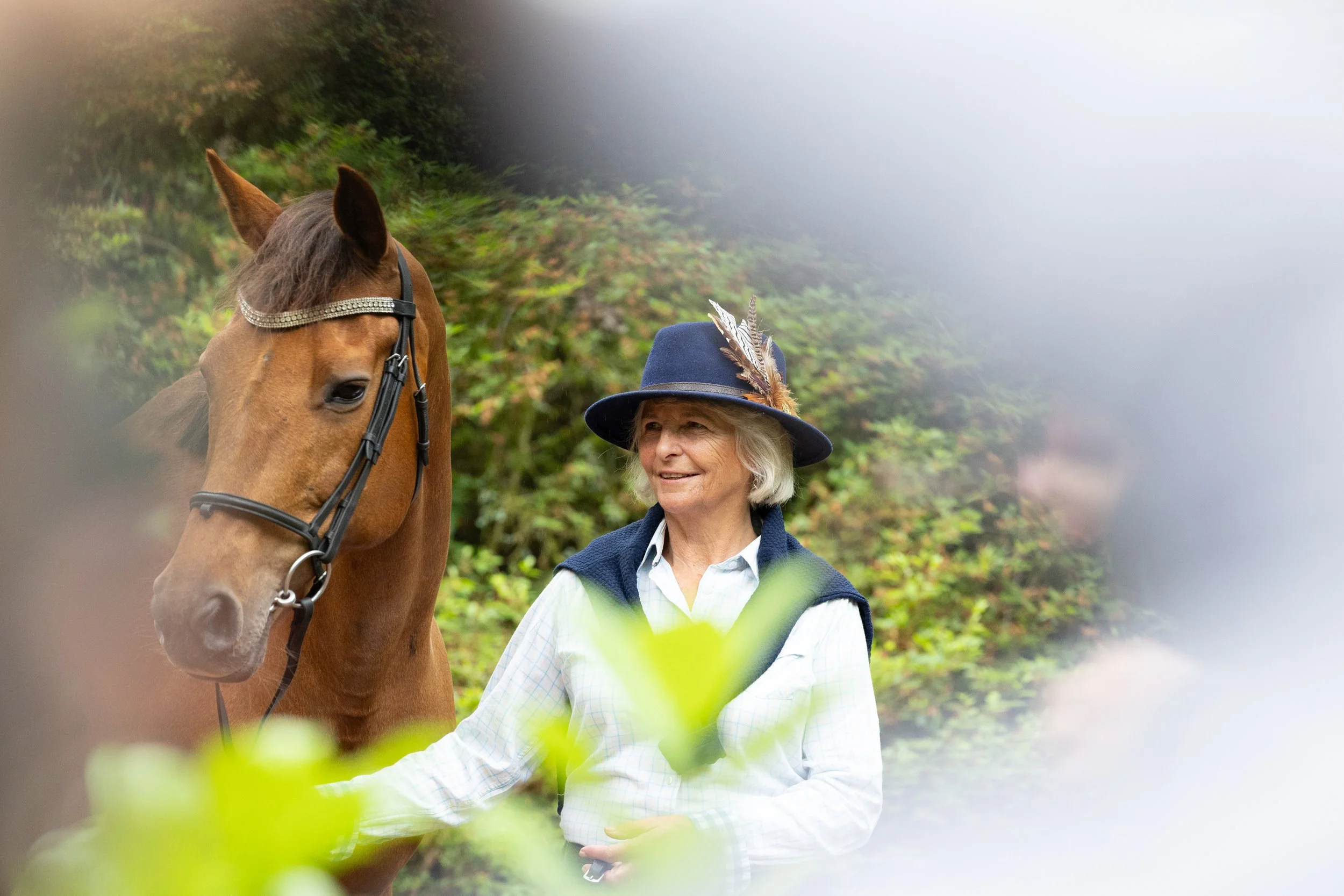 Lady wearing a hat holding her horse