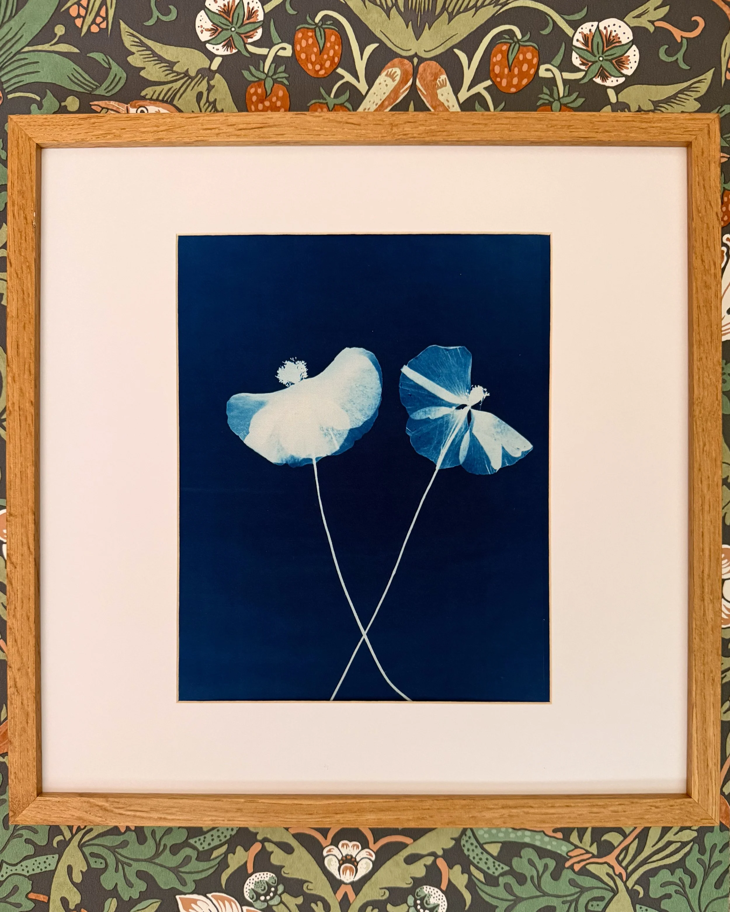 Framed digital artwork of two ginkgo leaves on a dark background, surrounded by decorative floral and botanical wallpaper.