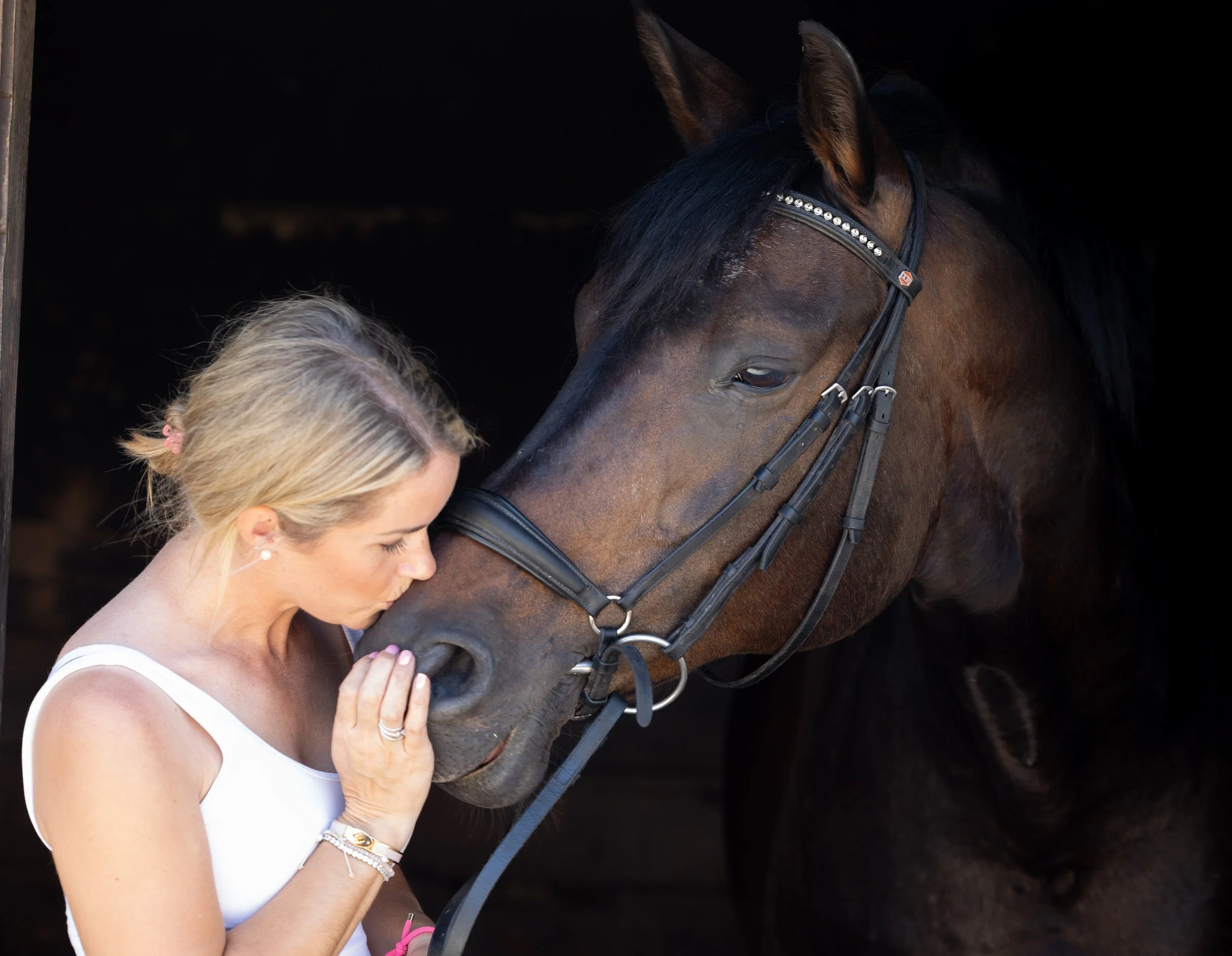Lady with her horse in the stable