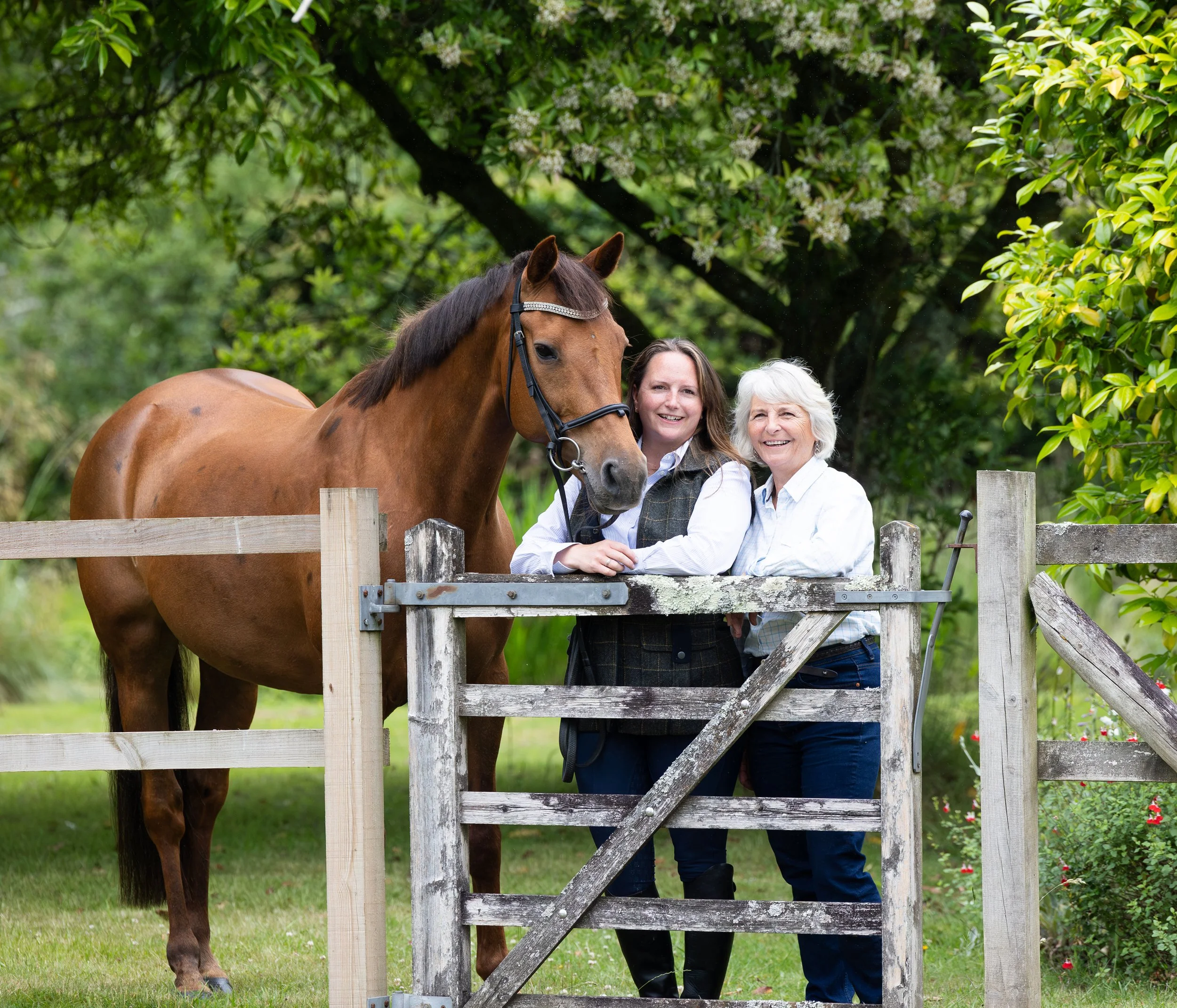 Mother and daughter standing next to their horse