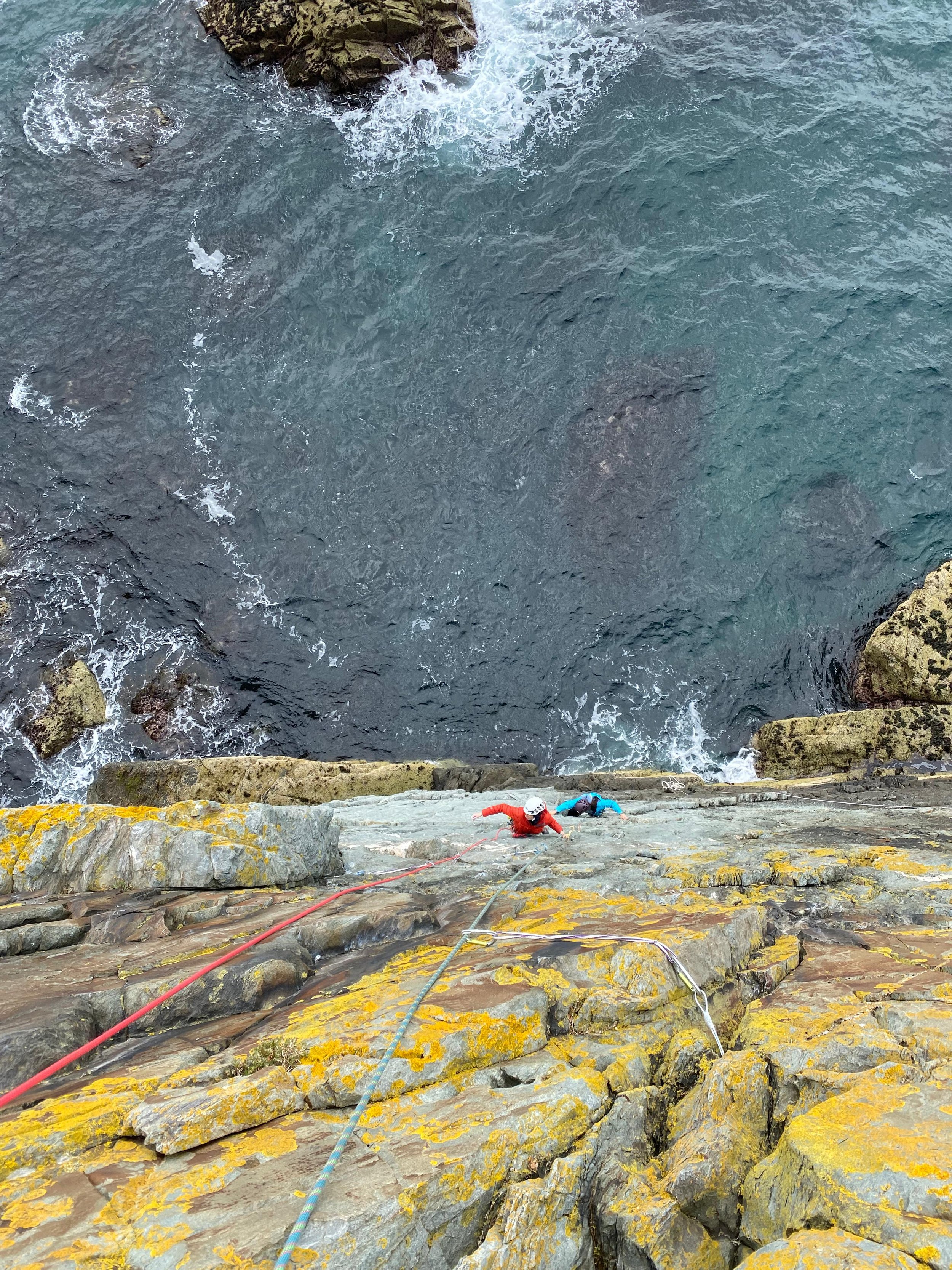 Two clients learning to sea cliff climb