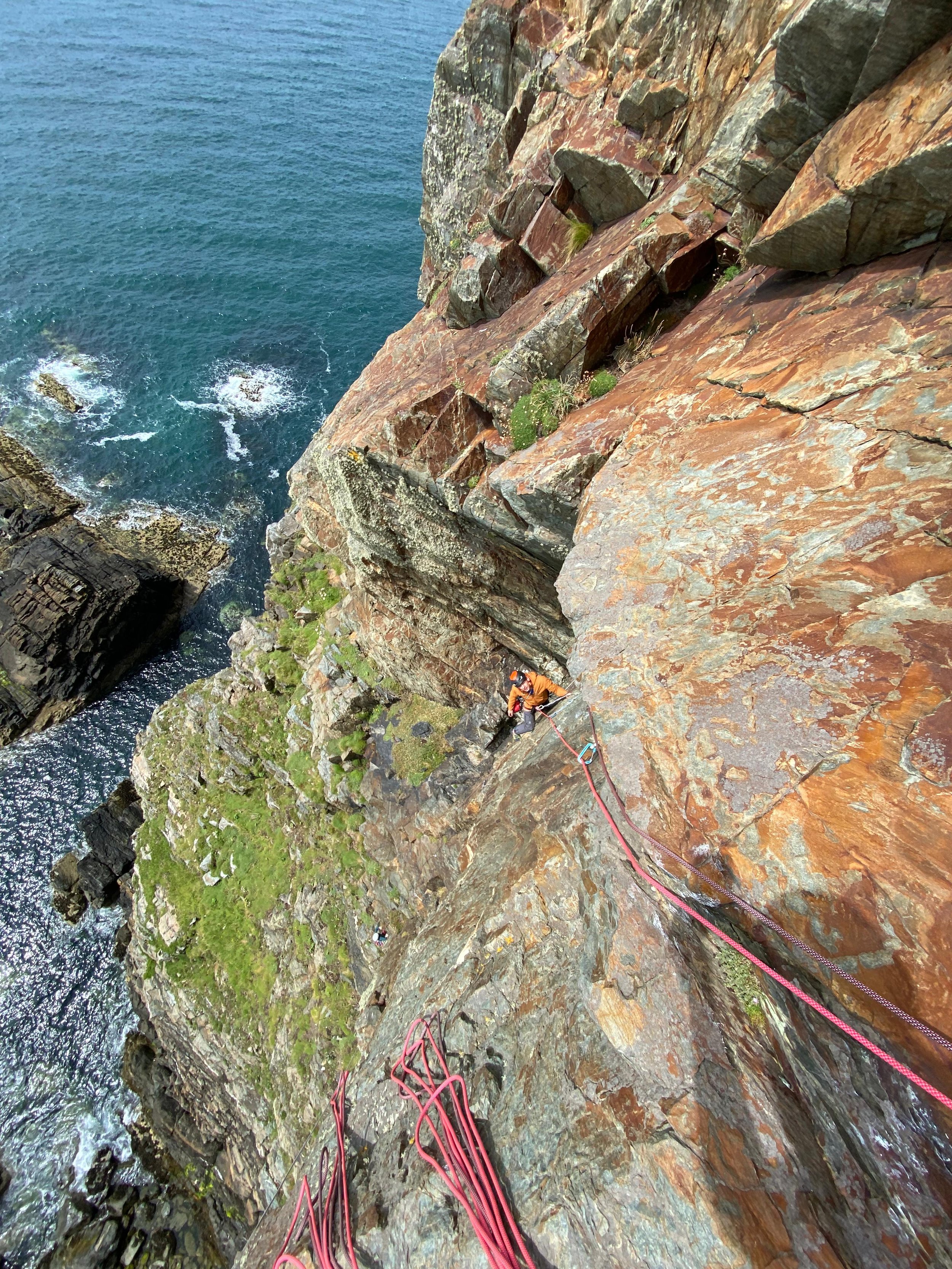 Two clients having a great time sea cliff climbing in Wales