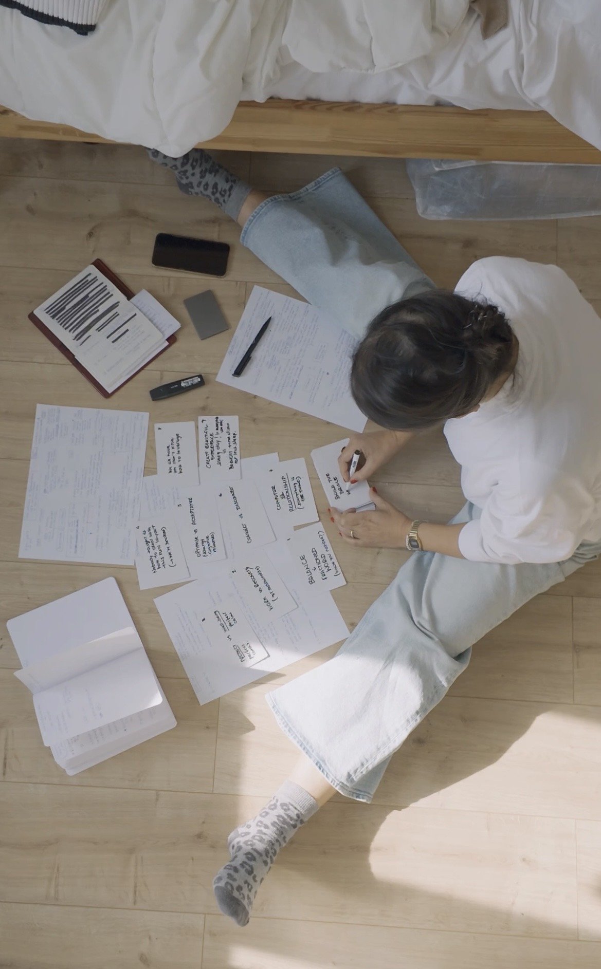 Concetta working on the floor, surrounded by notes and cards