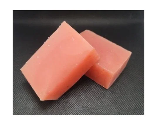 Two pink soap bars on a black surface