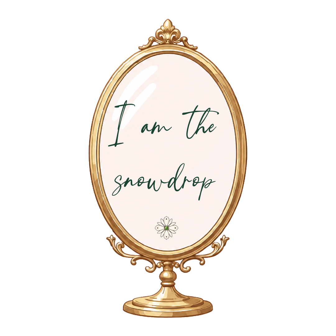 A decorative gold-framed mirror with a white background, displaying the text "I am the snowdrop" and a small illustration of a white snowdrop flower.
