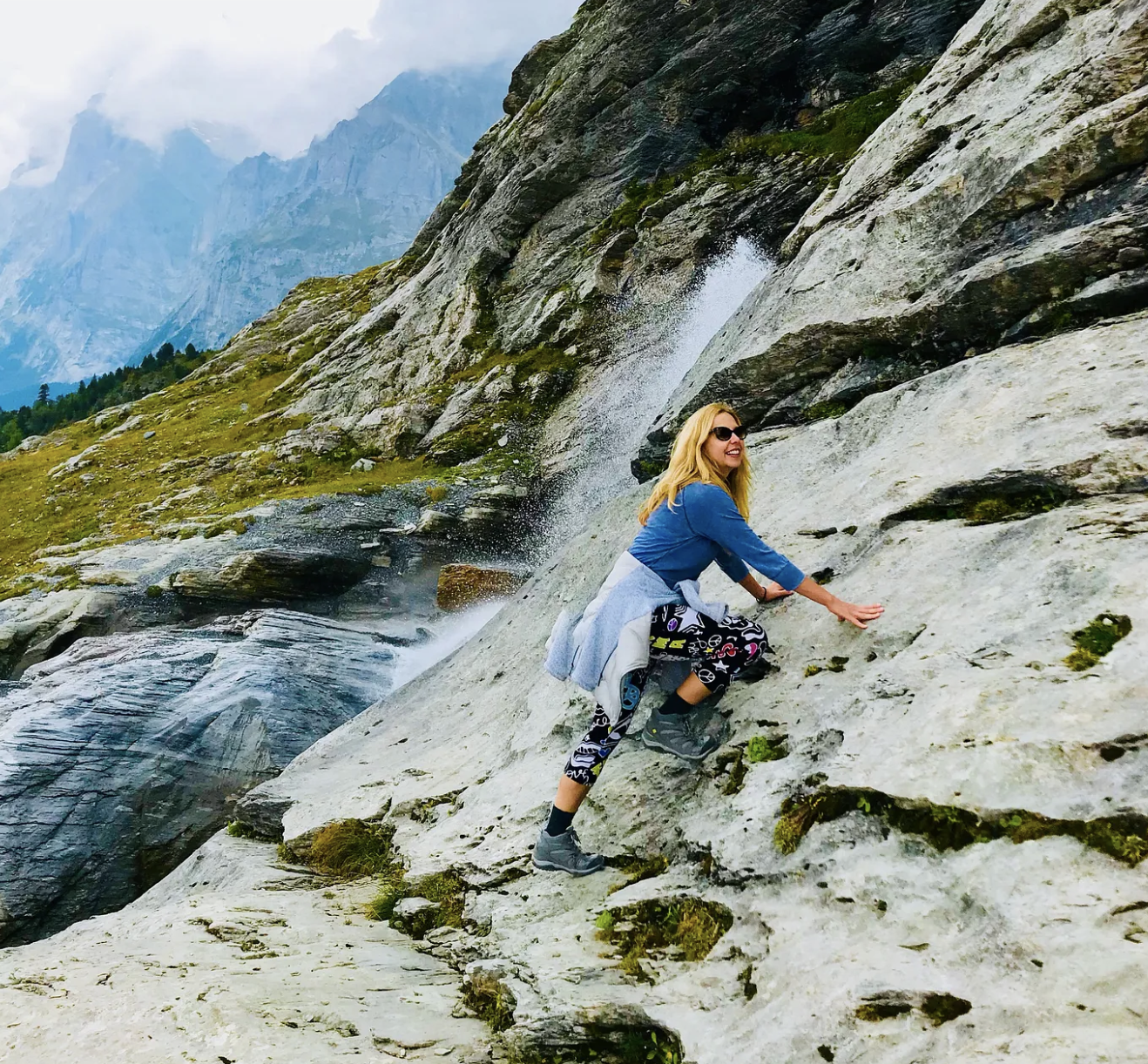 Kirsten climbing a rock with smoky mountains in the background