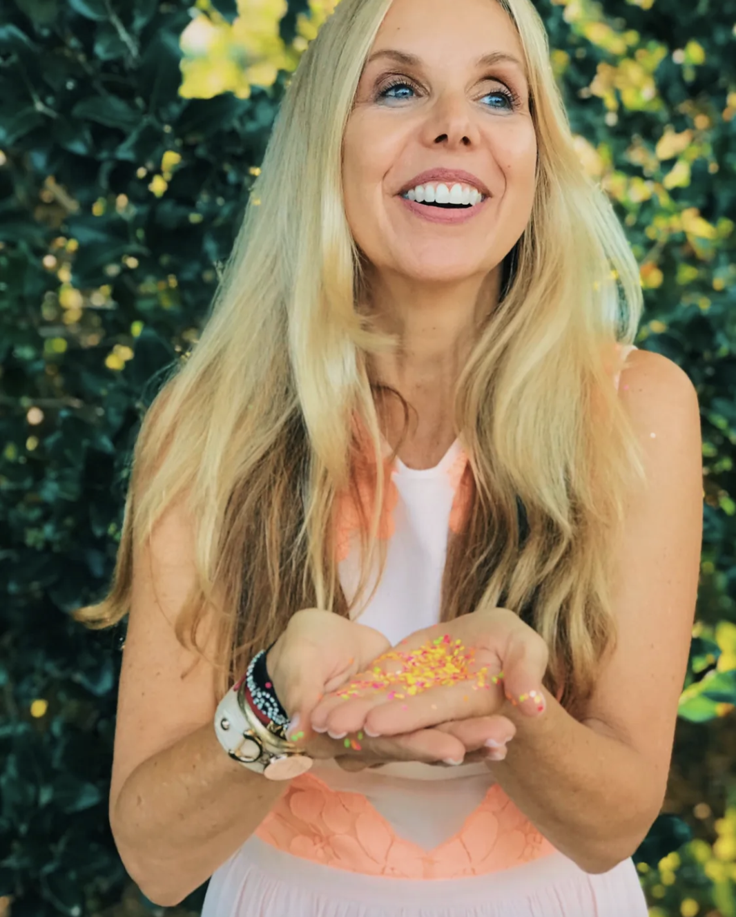 Kirsten Nelson Telan smiling holding confetti in her hand looking away from the camera