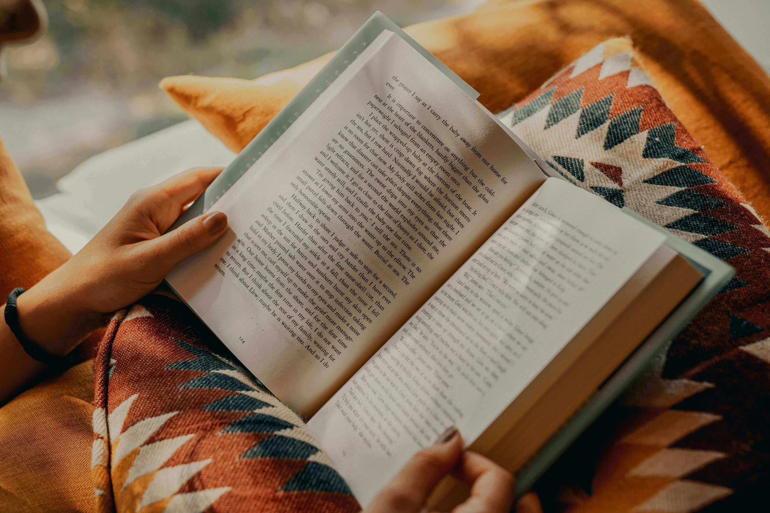Reader snuggled in cozy blanket with a book's opening chapter