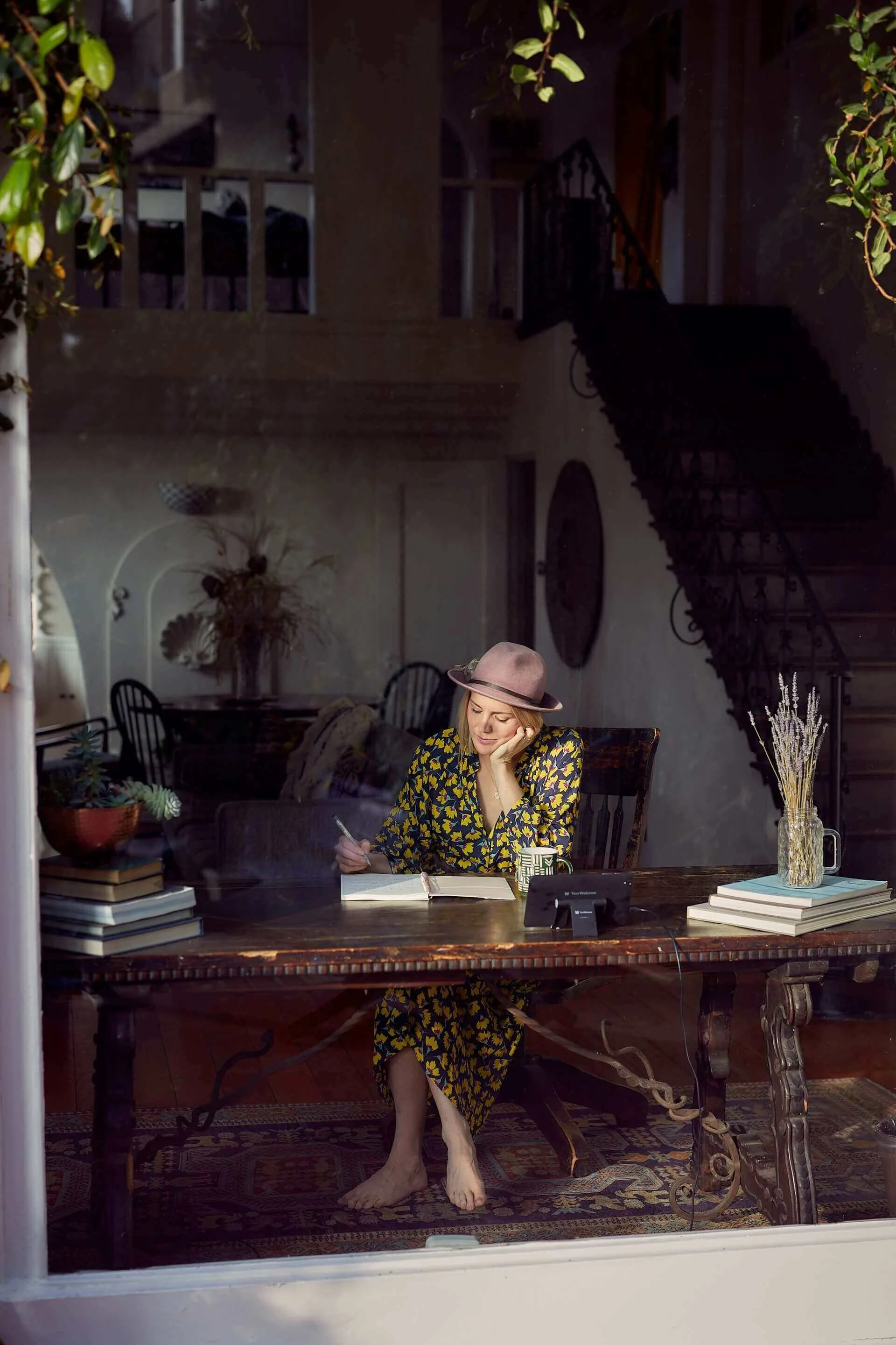 Author writes in notebook in countryside home