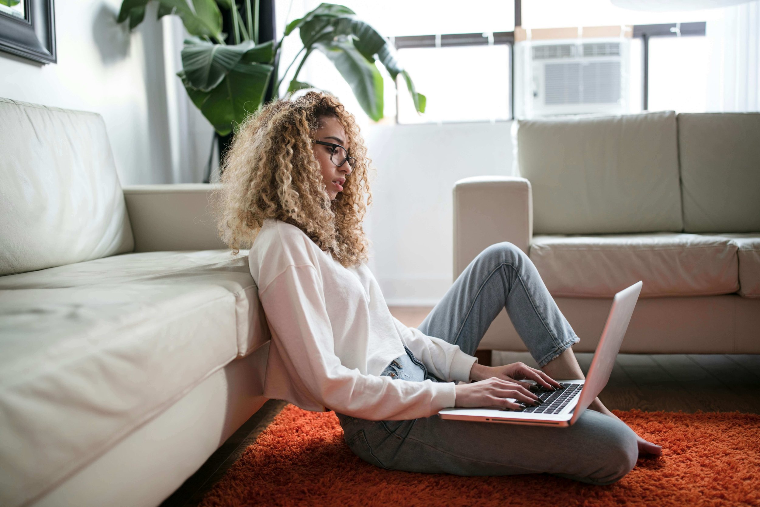 Relaxed, cozy, focused author learning on her laptop at home