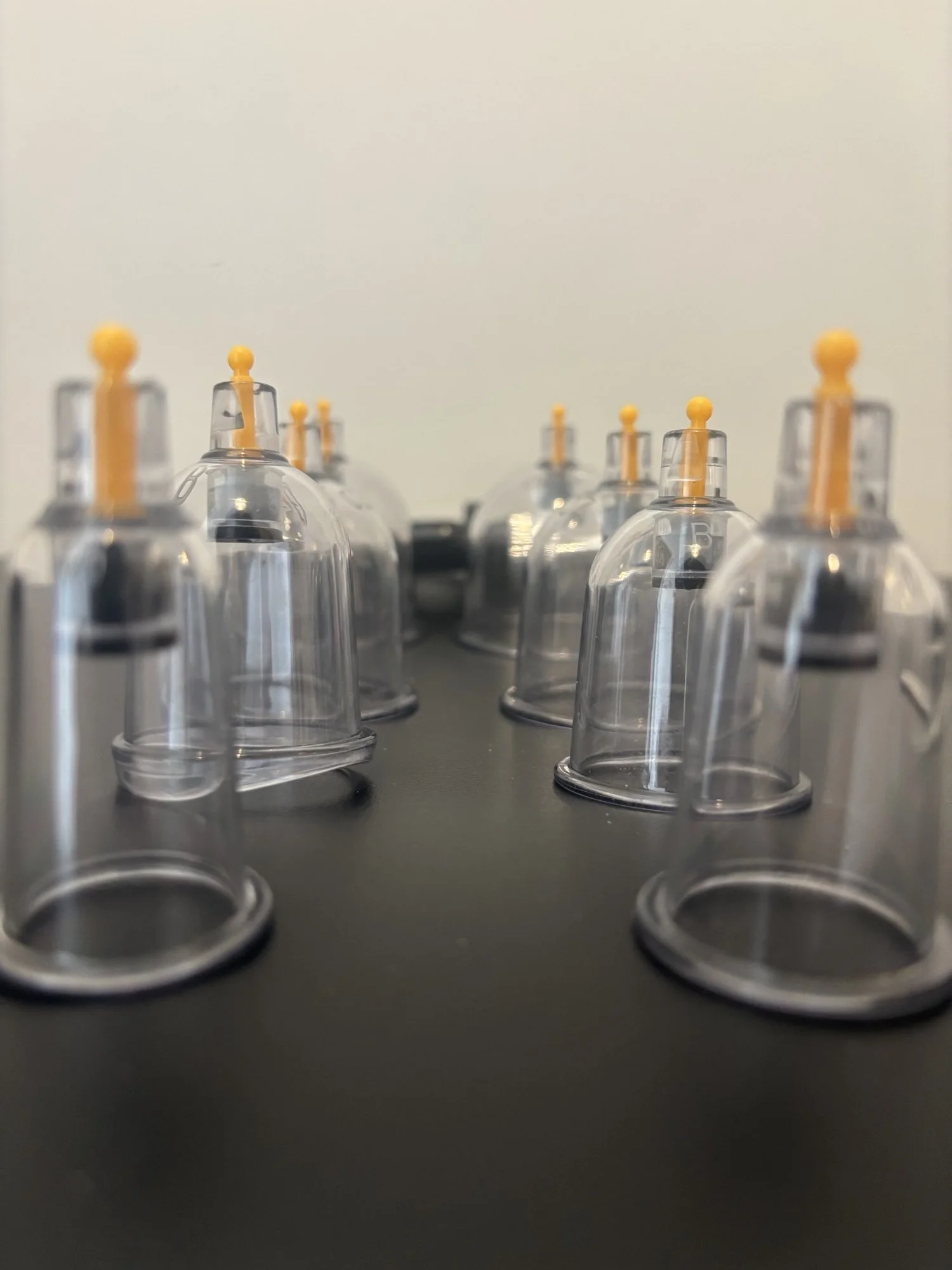 Multiple empty plastic laboratory test tubes with orange caps arranged in rows on a black surface.