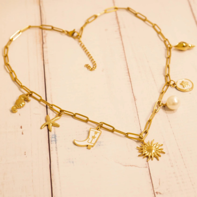 Gold charm bar necklace with adjustable chain and charms including a sun, pearl, starfish, boot, and initial, styled on a neutral background