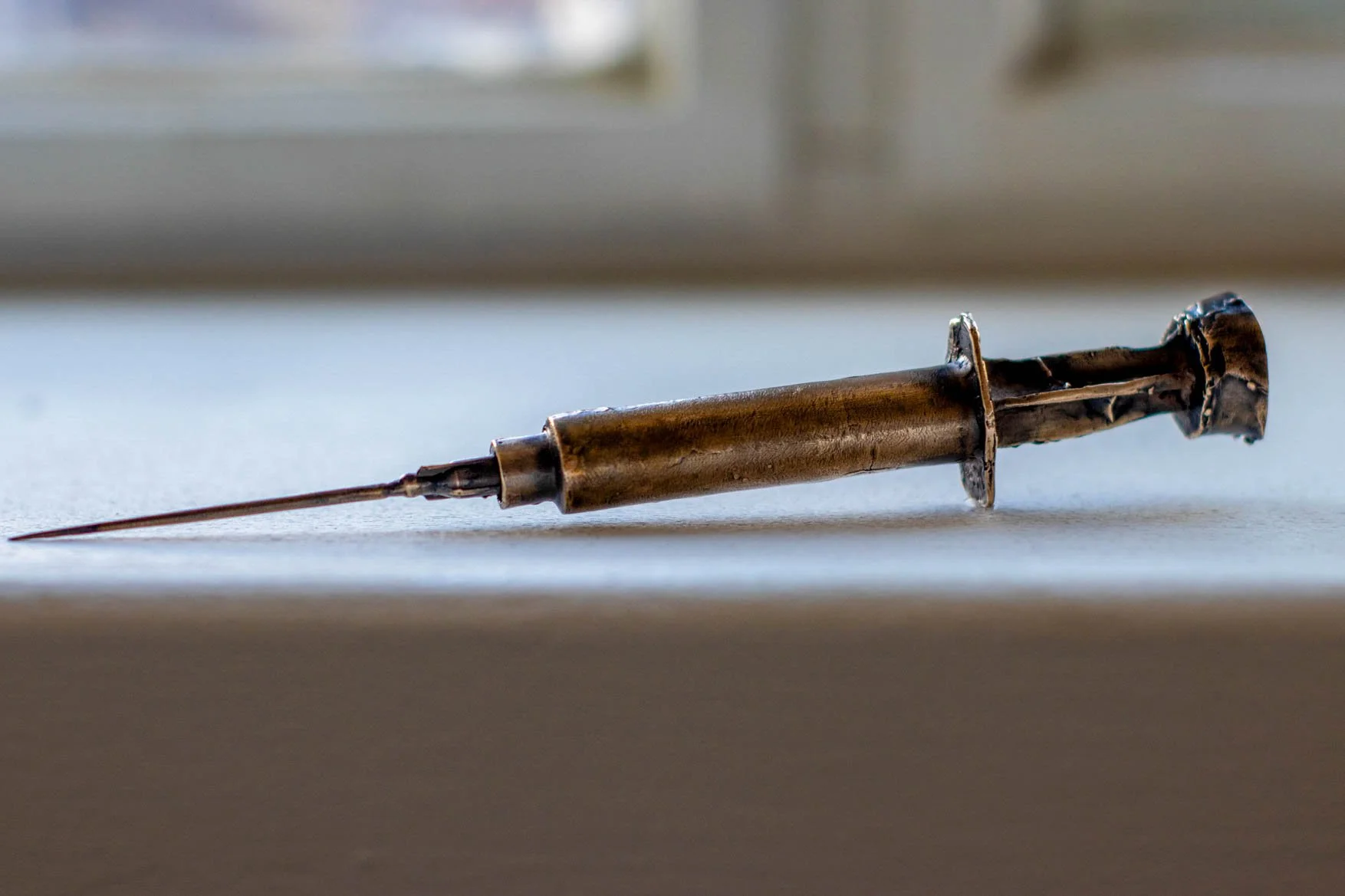 bronze syringe (17 × 1 cm)
