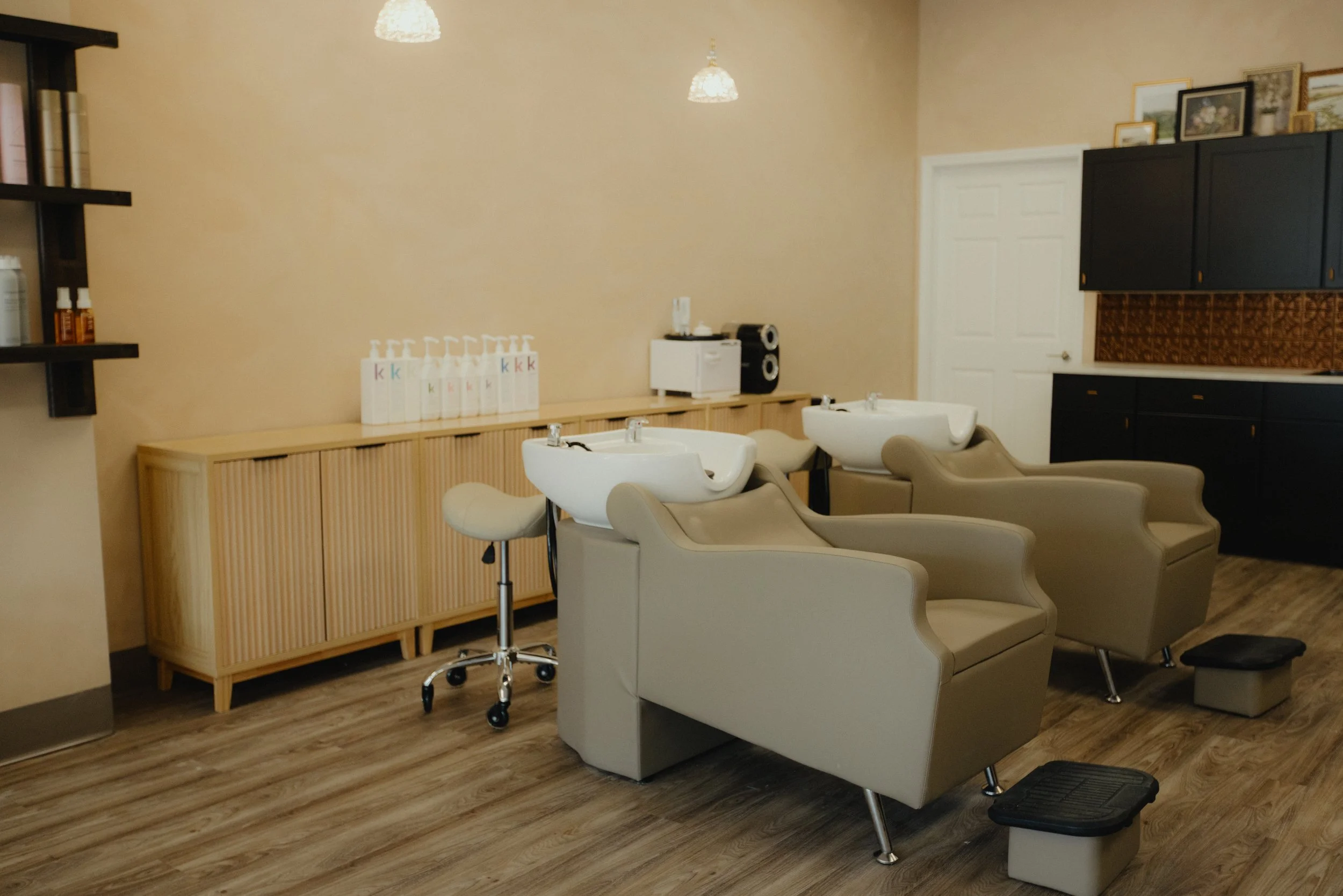 Reclining shampoo chairs at Nova Salon & Head Spa in Columbus, Ohio, featuring footrests and Kevin Murphy shampoo and conditioner at the backbar