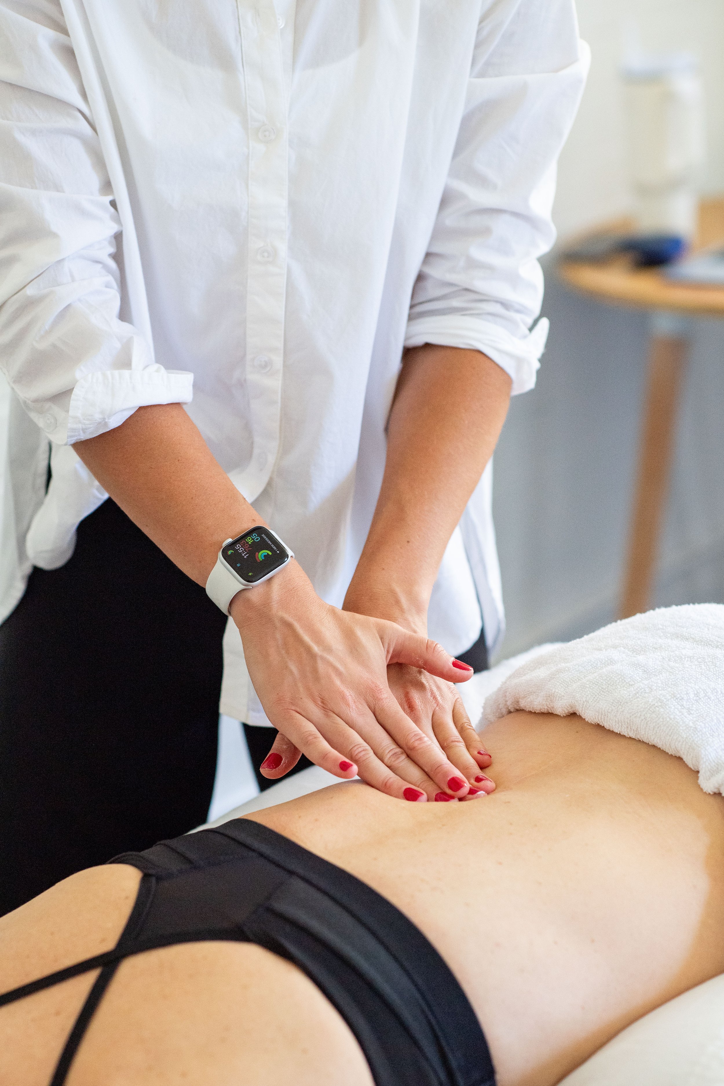 A person receiving a massage on their back from a massage therapist in a spa or clinic setting.