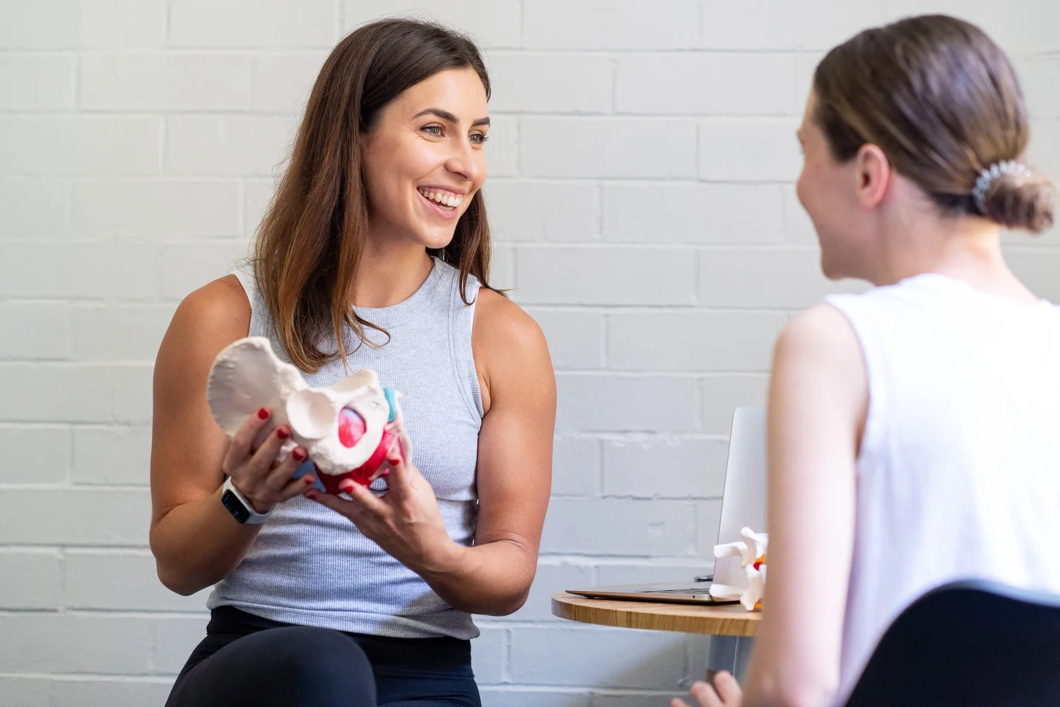 Women's health physio explaining the pelvic floor with a model at Base Physiotherapy & Pilates, Drummoyne