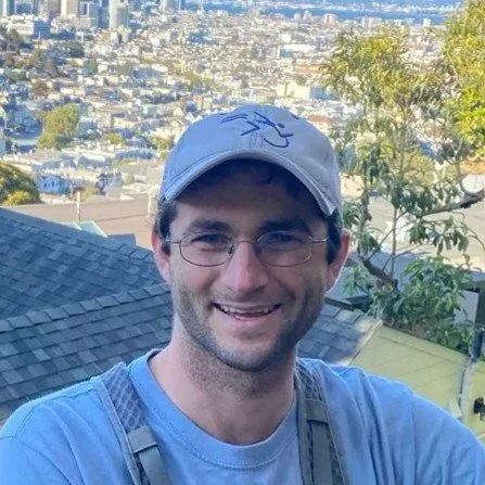 Eric posing with a city view in the background