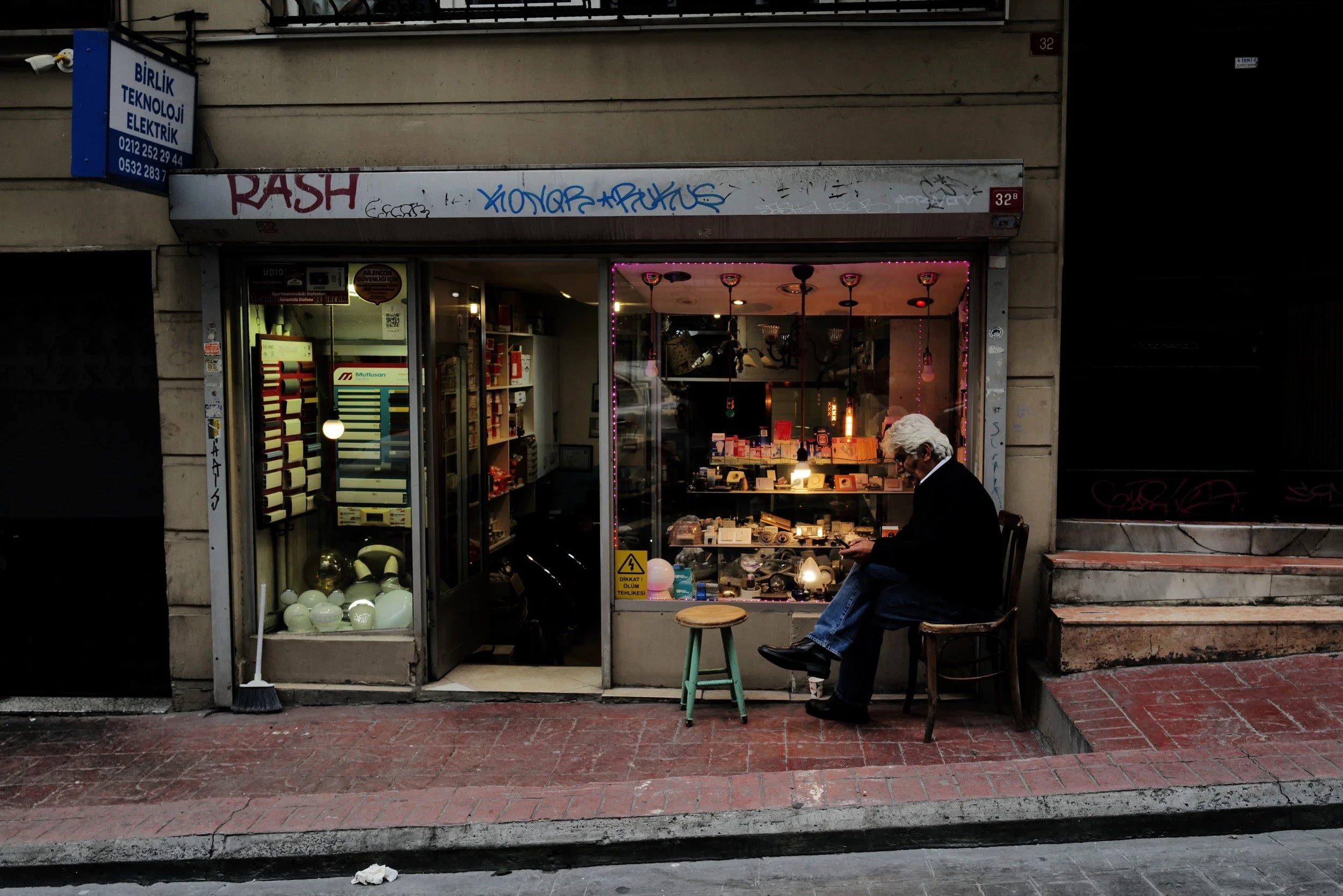 A man sitting outside a small shop