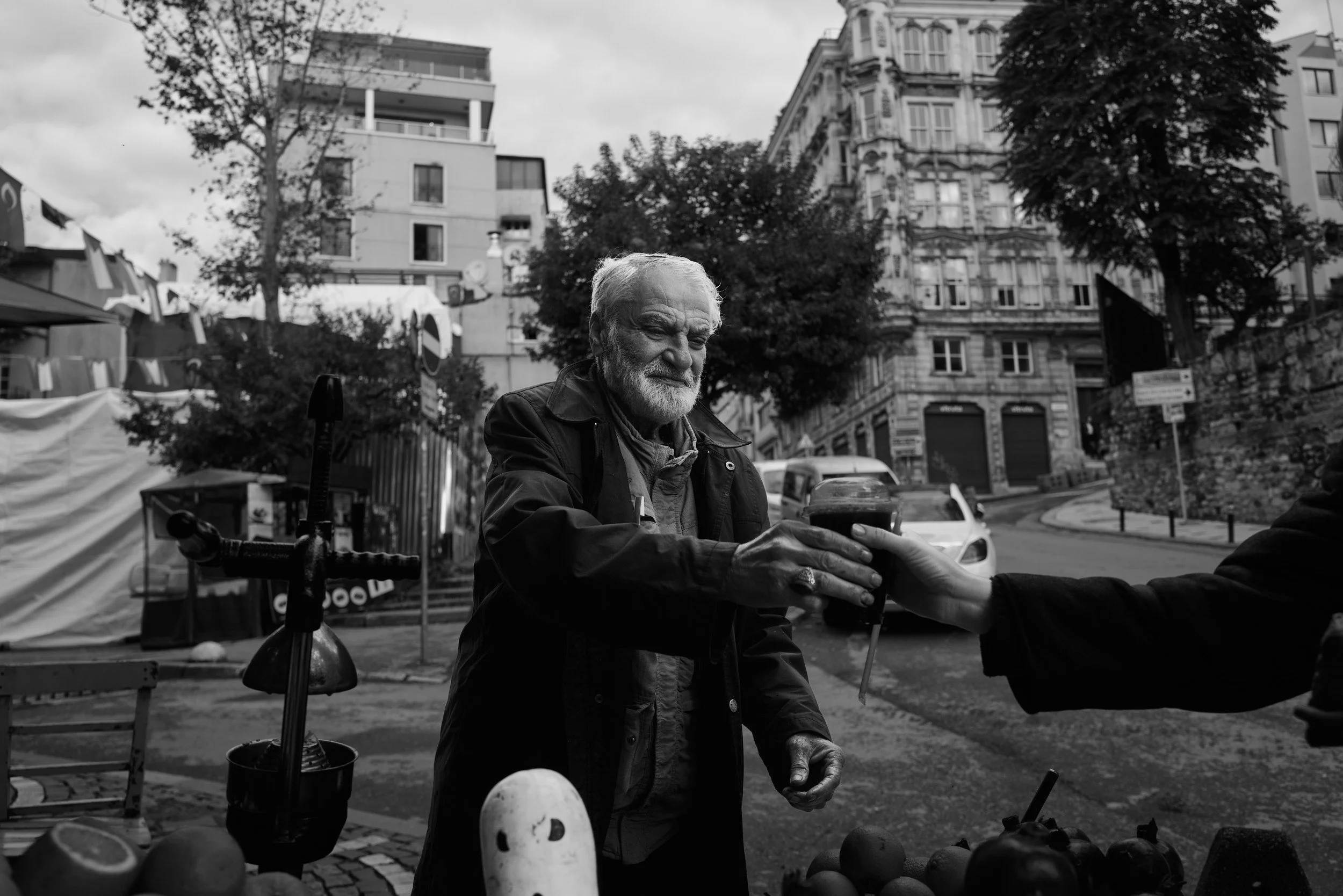 A man offering a small glass in the street