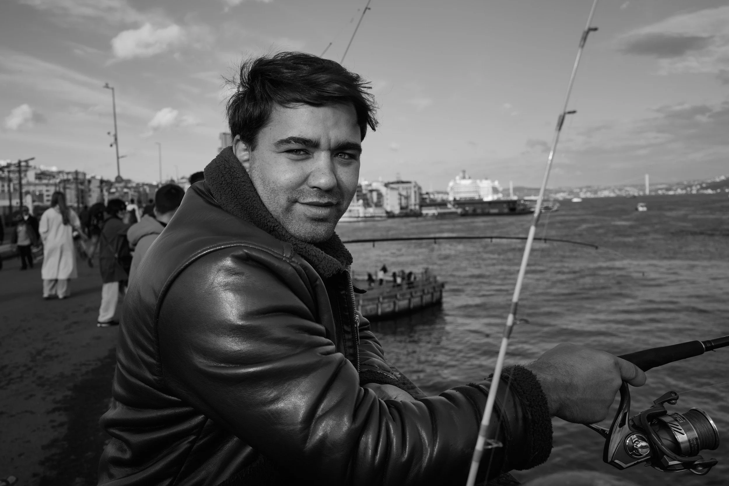 A fisherman holding his rod by the water