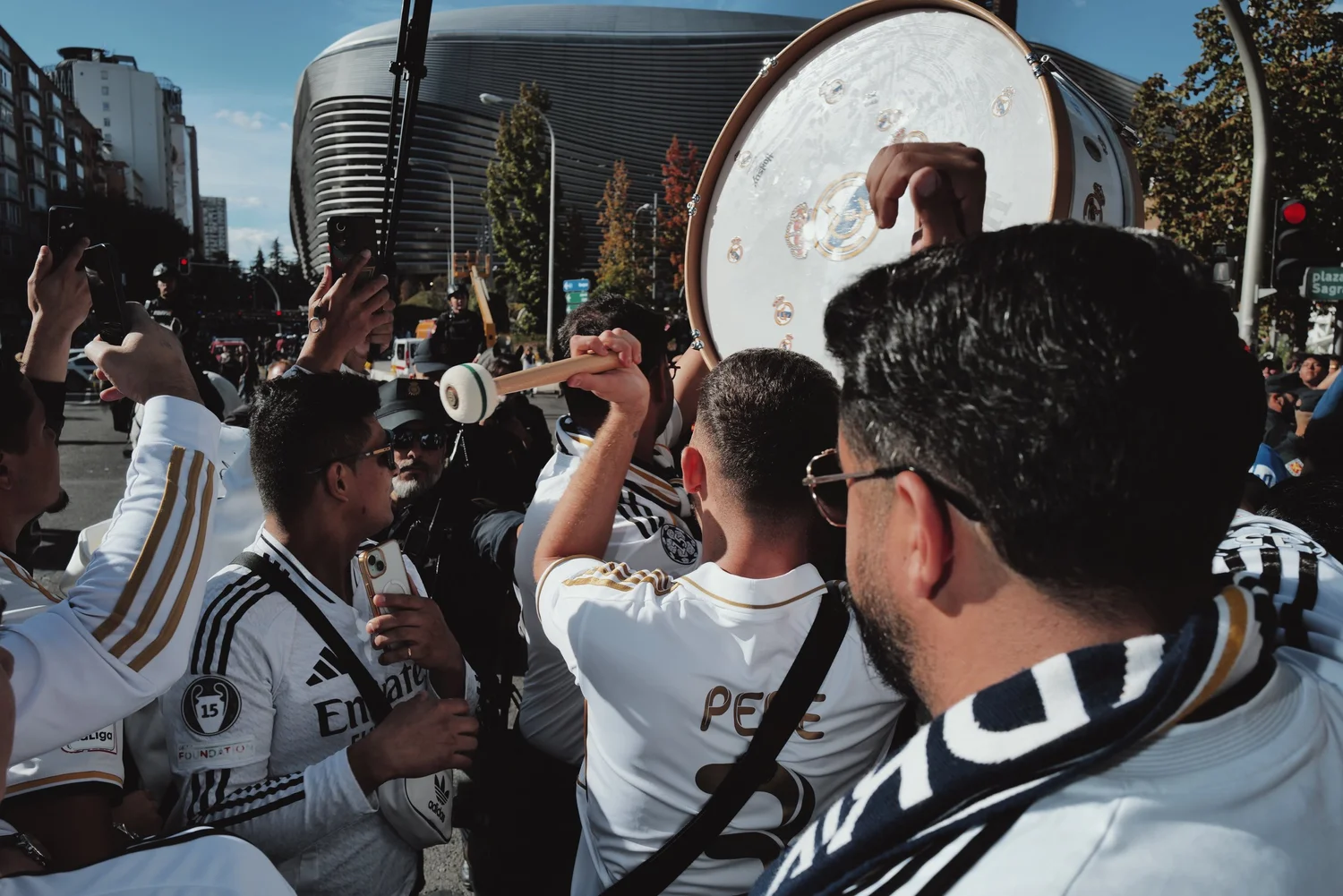 A supporter raises a drum among the crowd