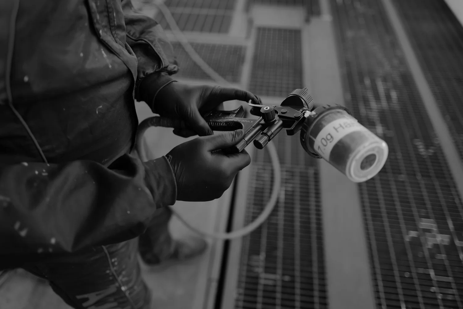 Hands adjusting a spray gun in the paint shop