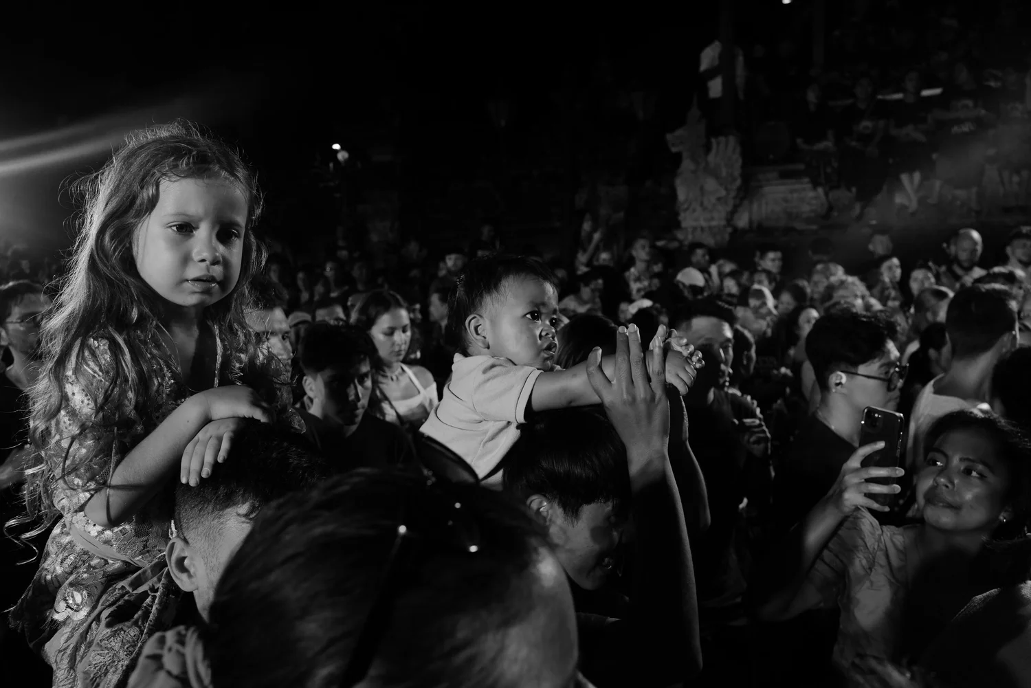 Children watching the procession from adults’ shoulders